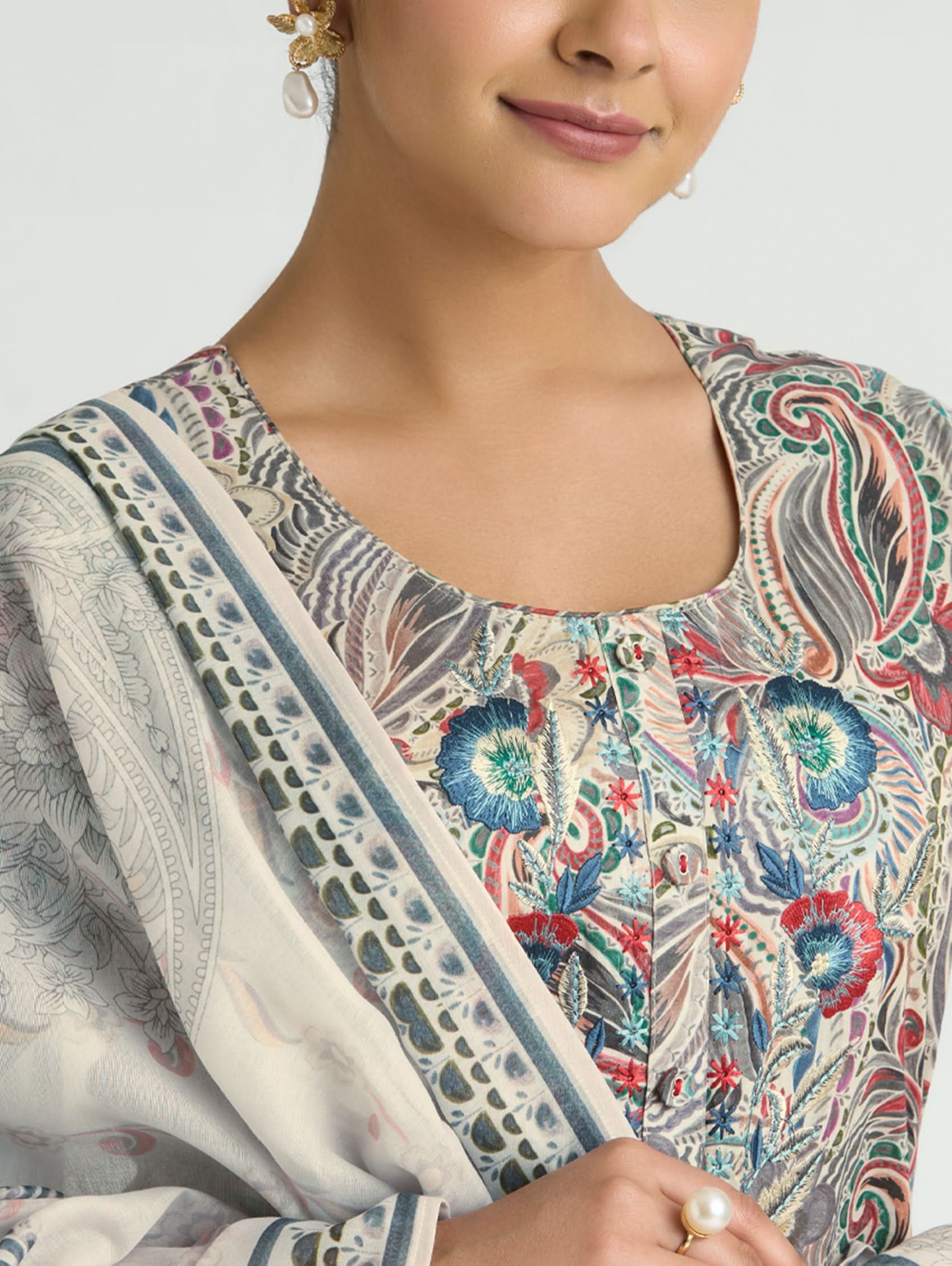 Woman wearing a patterned outfit with a focus on the neckline and shoulders.
