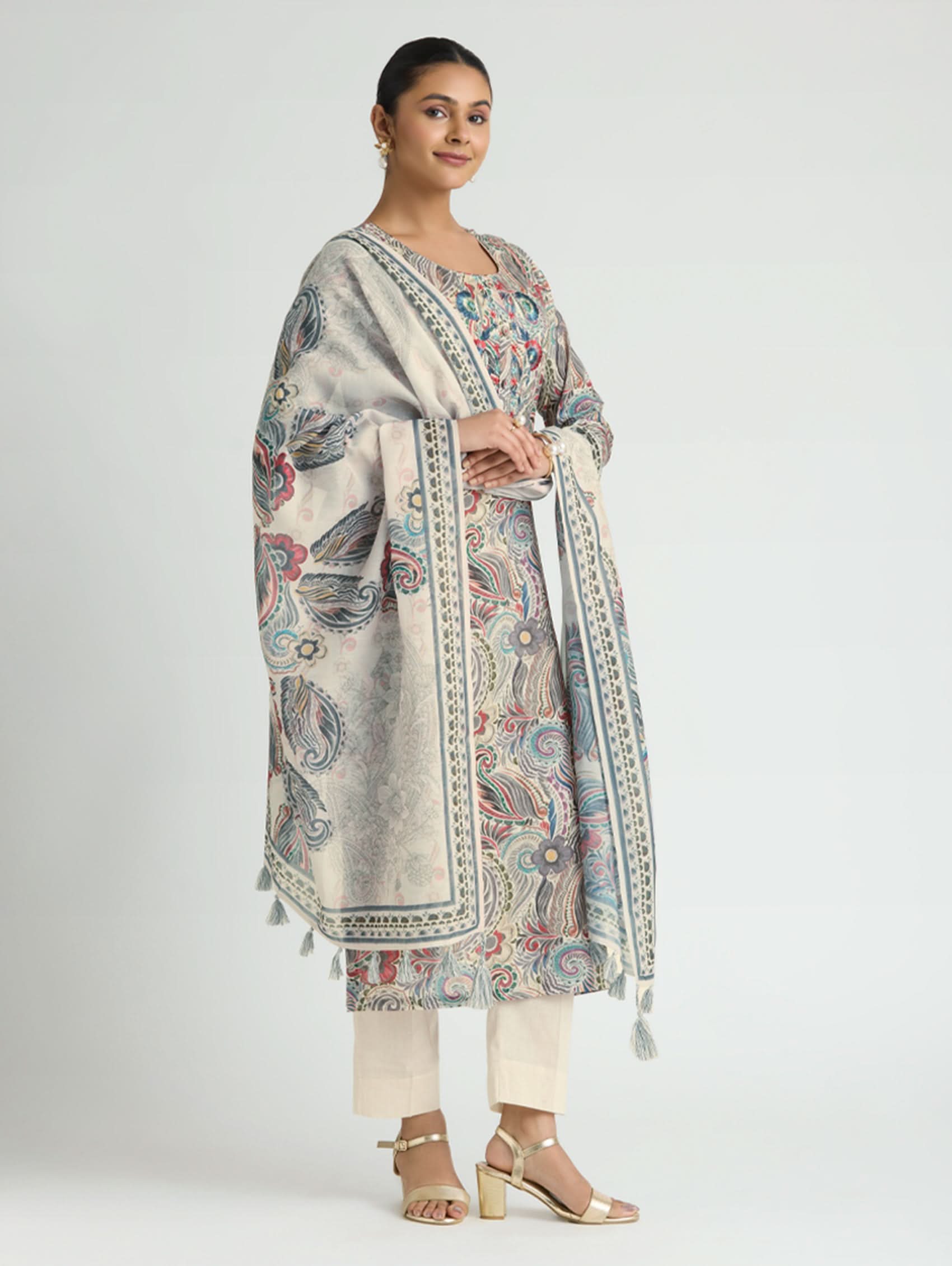 Woman wearing a patterned kurta with a matching dupatta on a white background