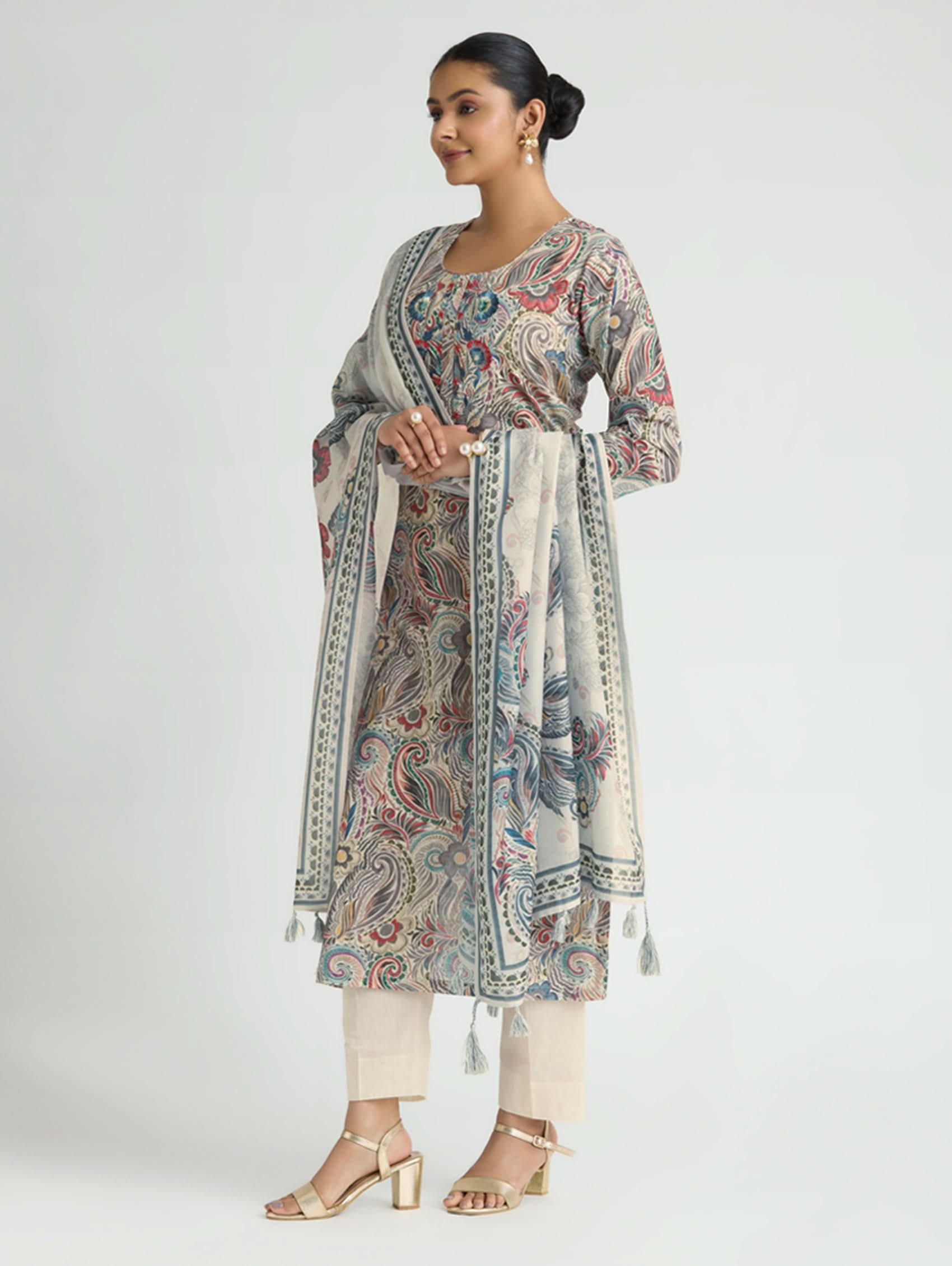 Woman wearing a patterned kurta with a matching dupatta on a white background