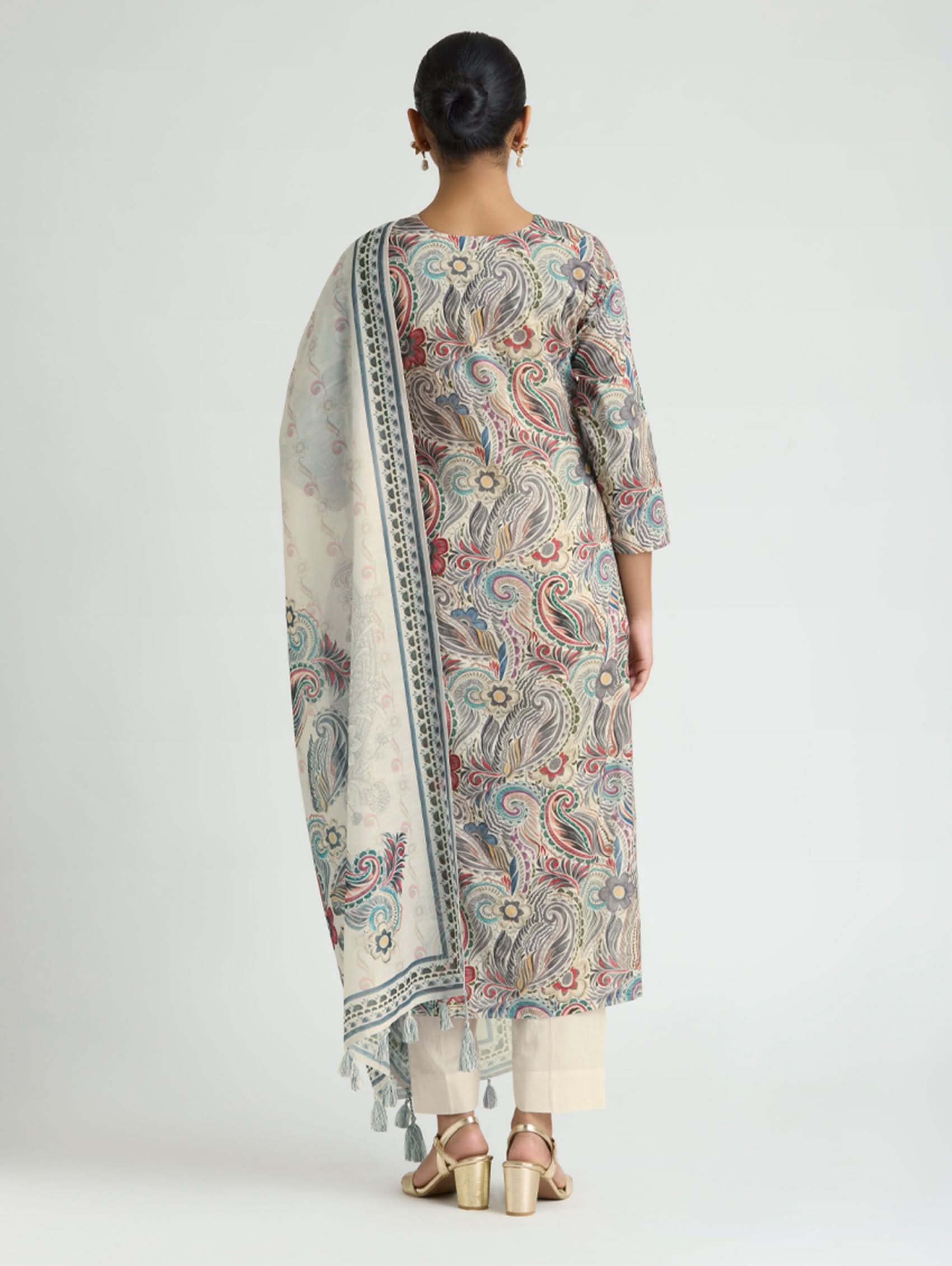 Woman wearing a patterned kurta with a matching dupatta on a white background