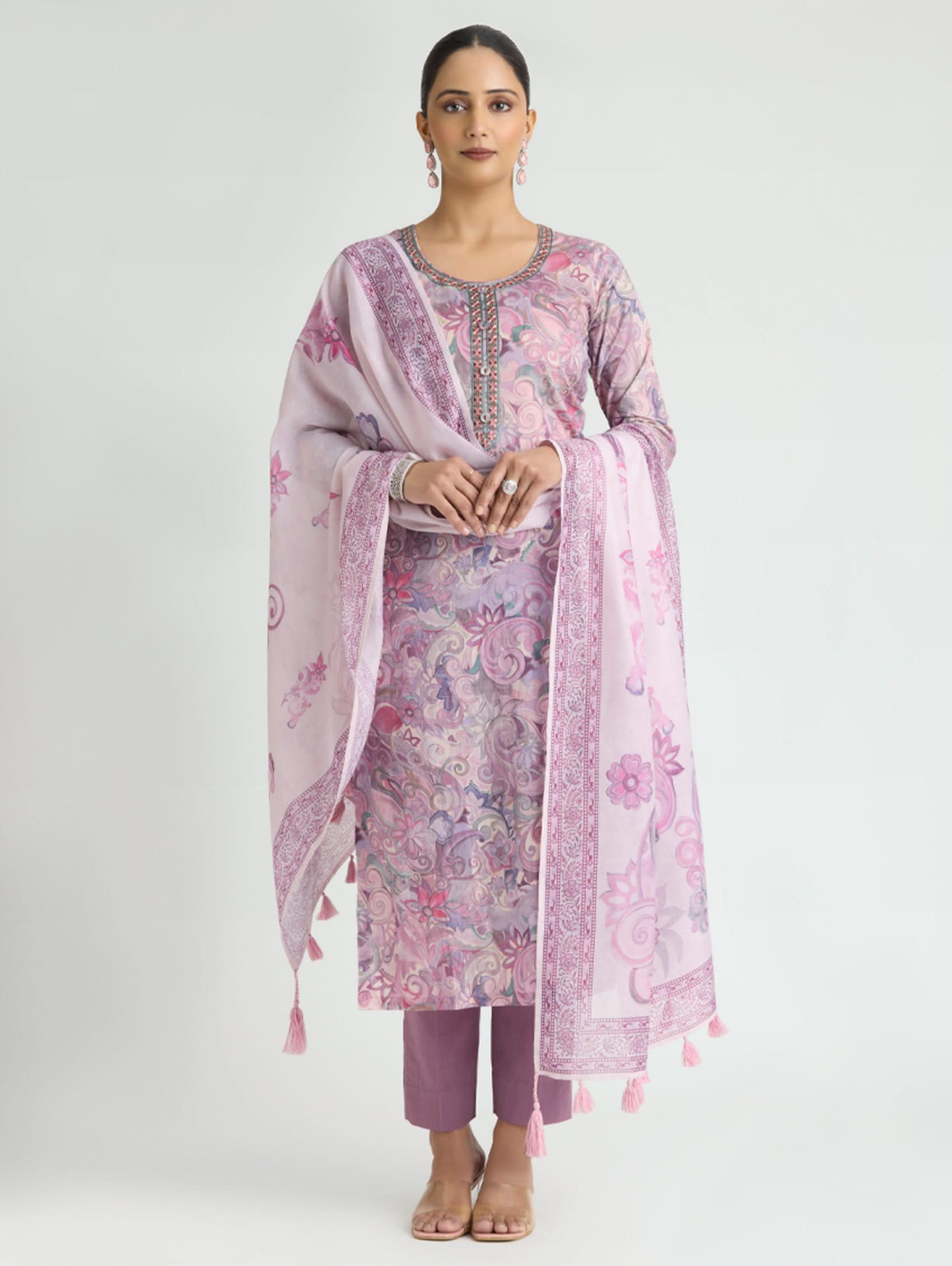 Woman wearing a pink floral outfit with a matching dupatta on a white background