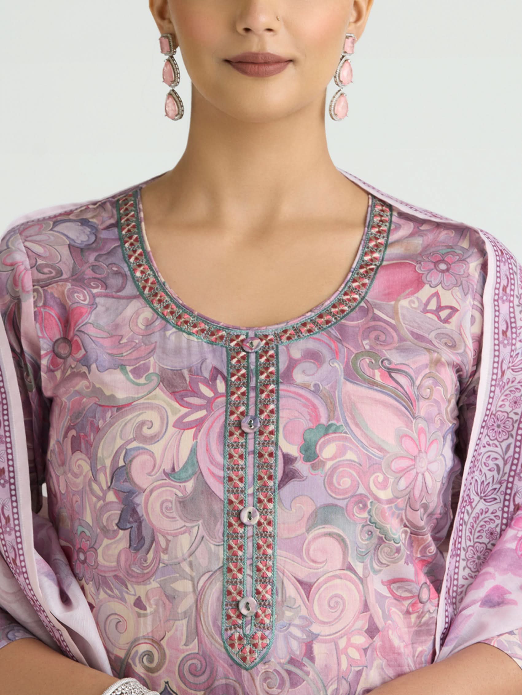 Close-up of a person wearing a pink and purple patterned outfit with intricate detailing.