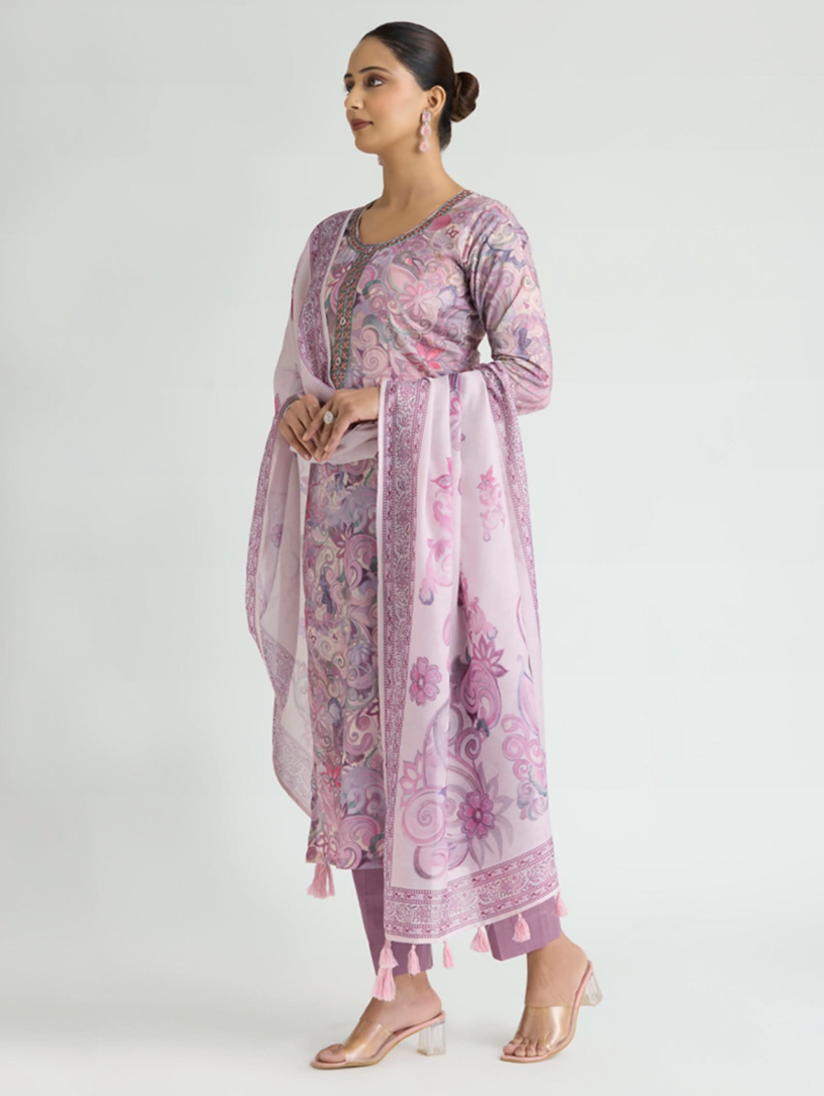 Woman wearing a pink floral kurta with matching dupatta on a white background