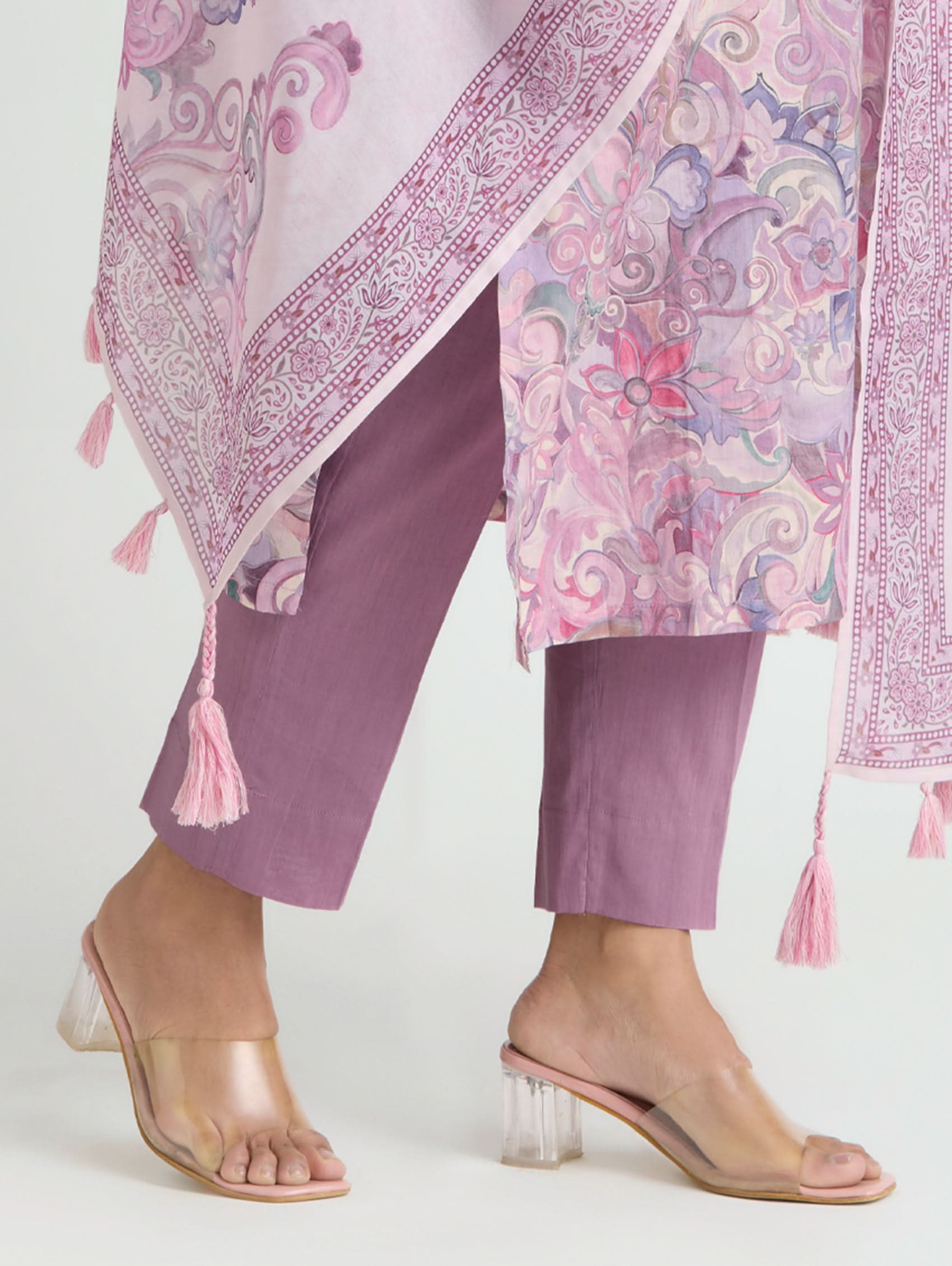 Person wearing a pink and purple traditional outfit with a matching dupatta on a white background