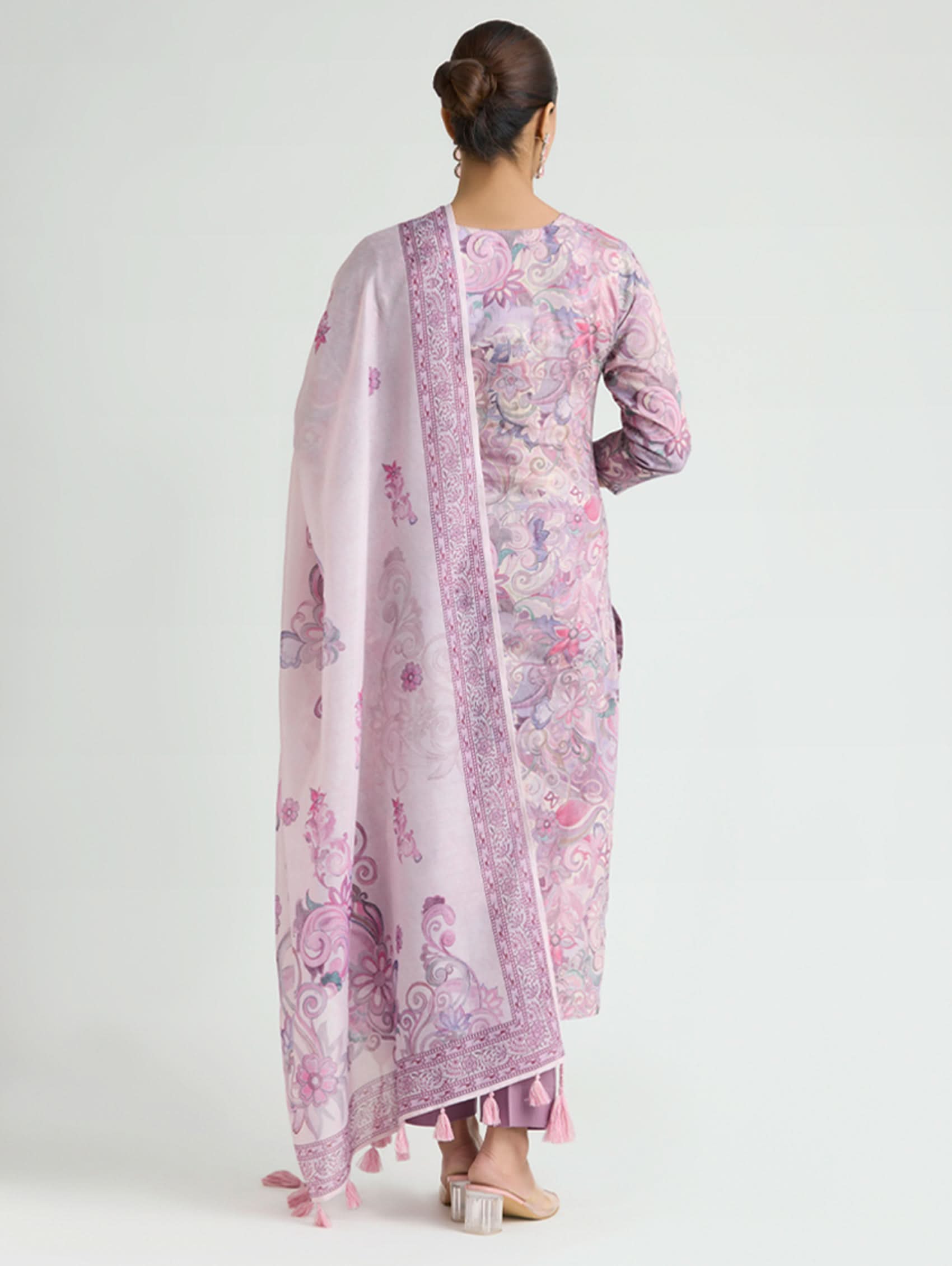 Woman wearing a floral kurta with a matching dupatta on a white background