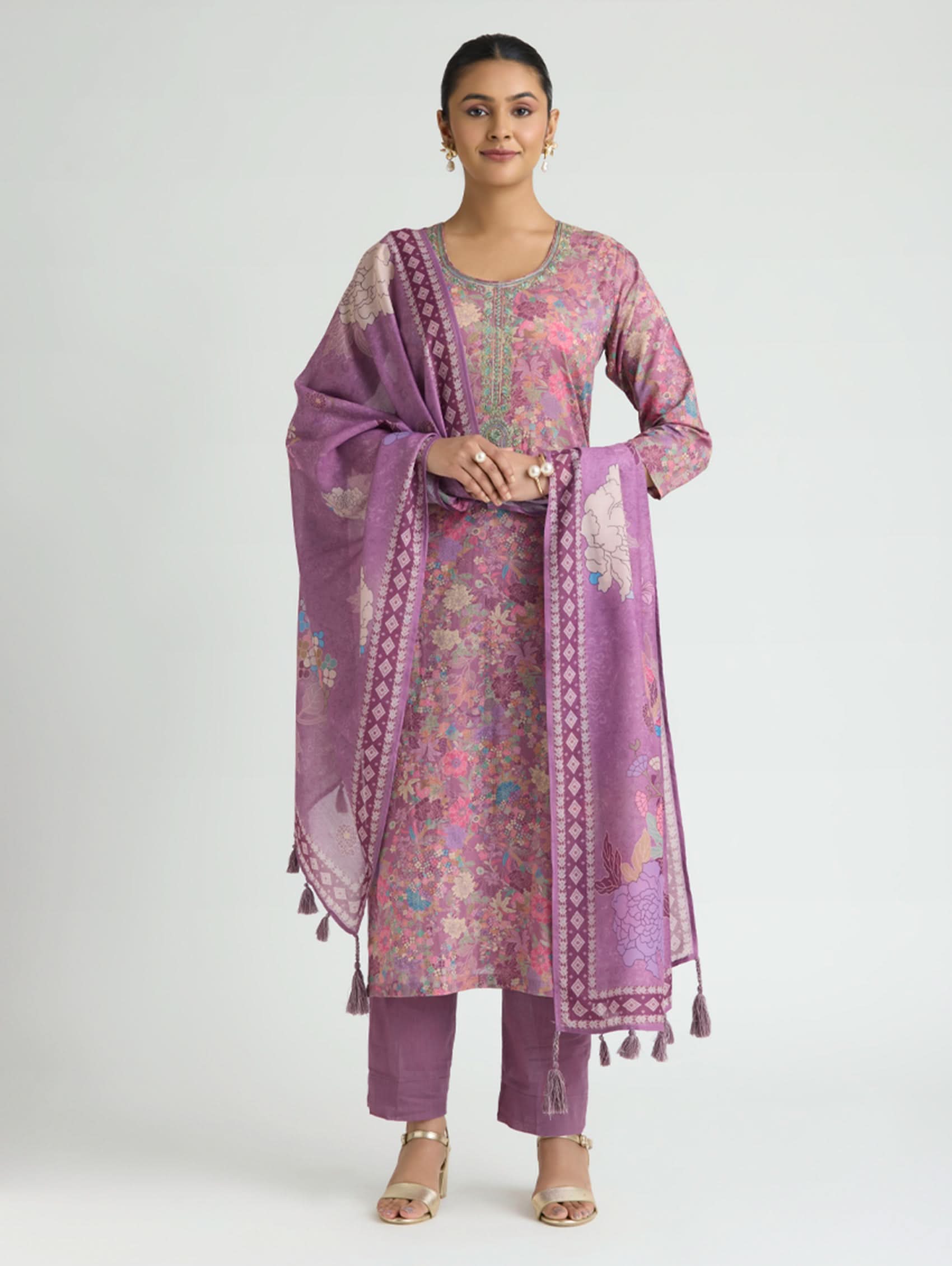 Woman wearing a purple traditional outfit with a matching dupatta on a white background