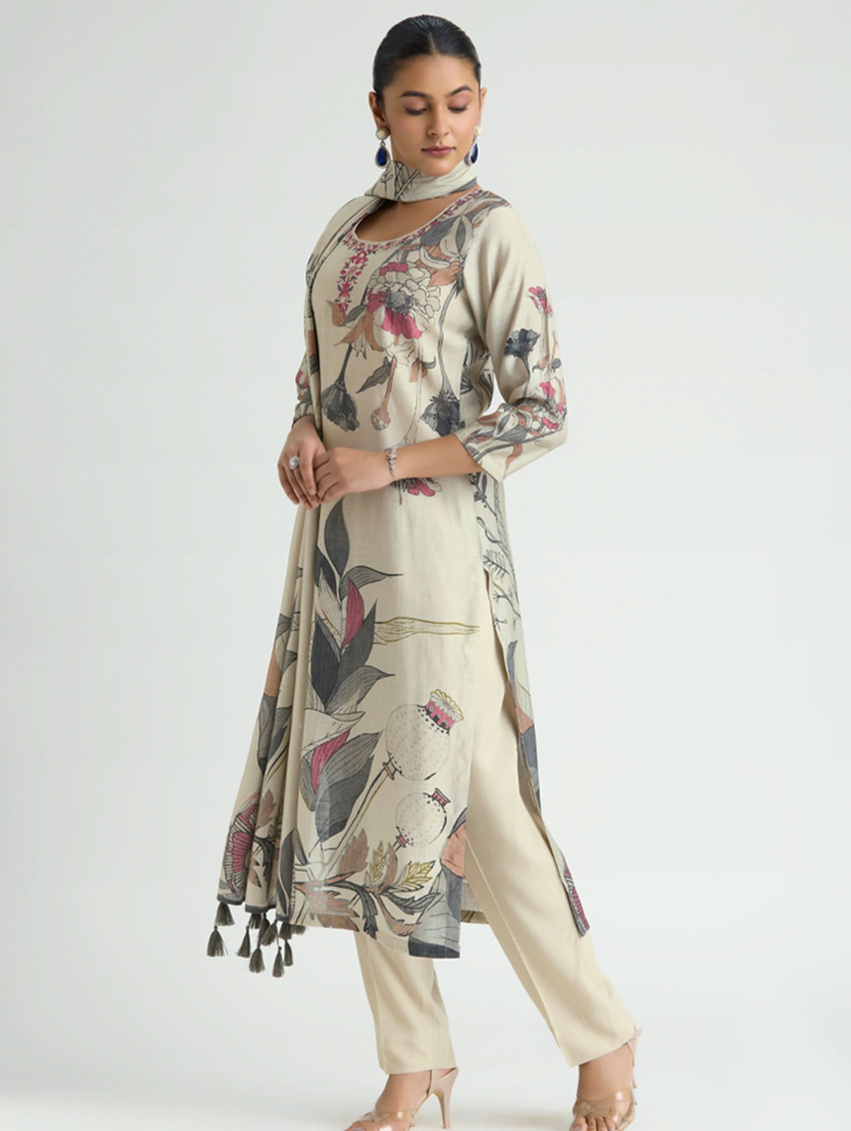 Woman wearing a floral printed outfit with tassels on a white background