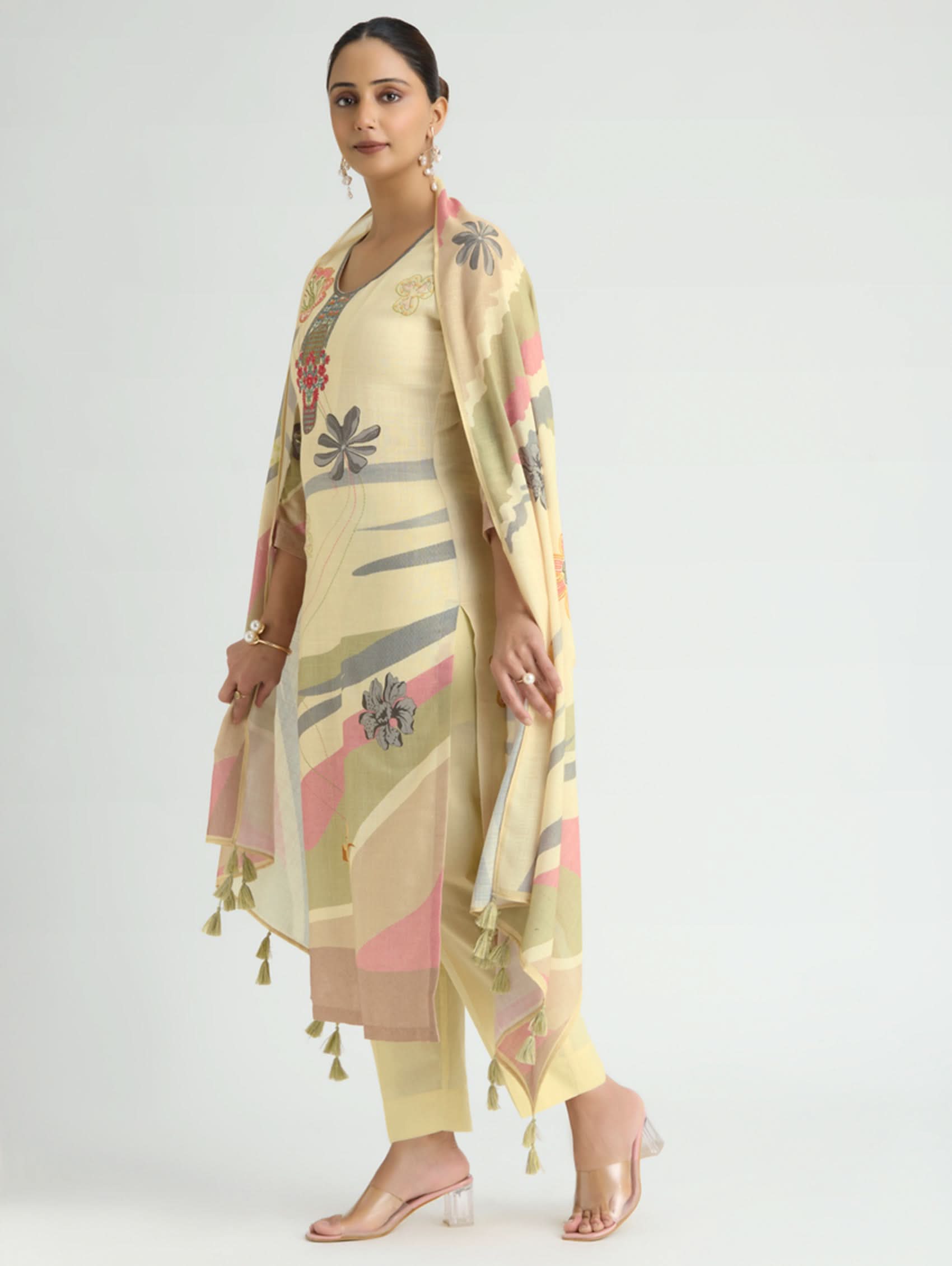 Woman wearing a light yellow floral patterned outfit on a white background