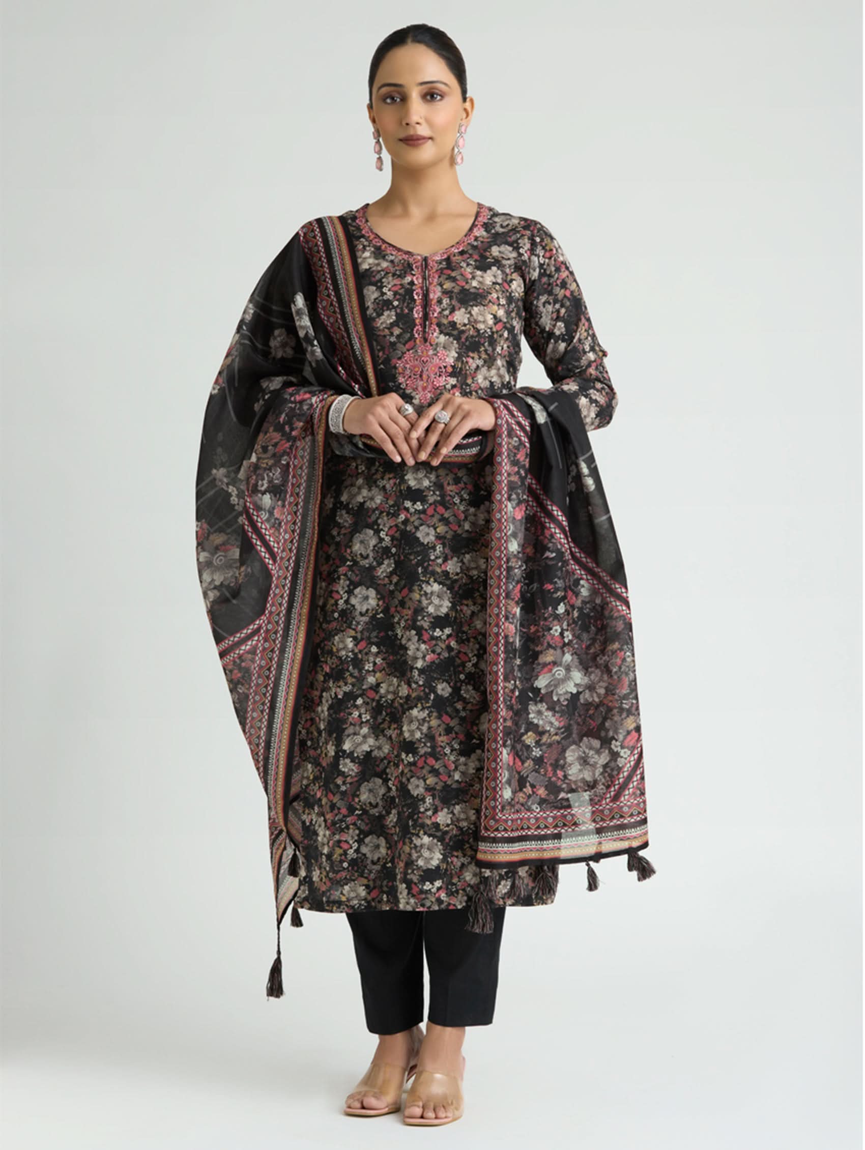 Woman wearing a floral kurta with a matching dupatta on a white background