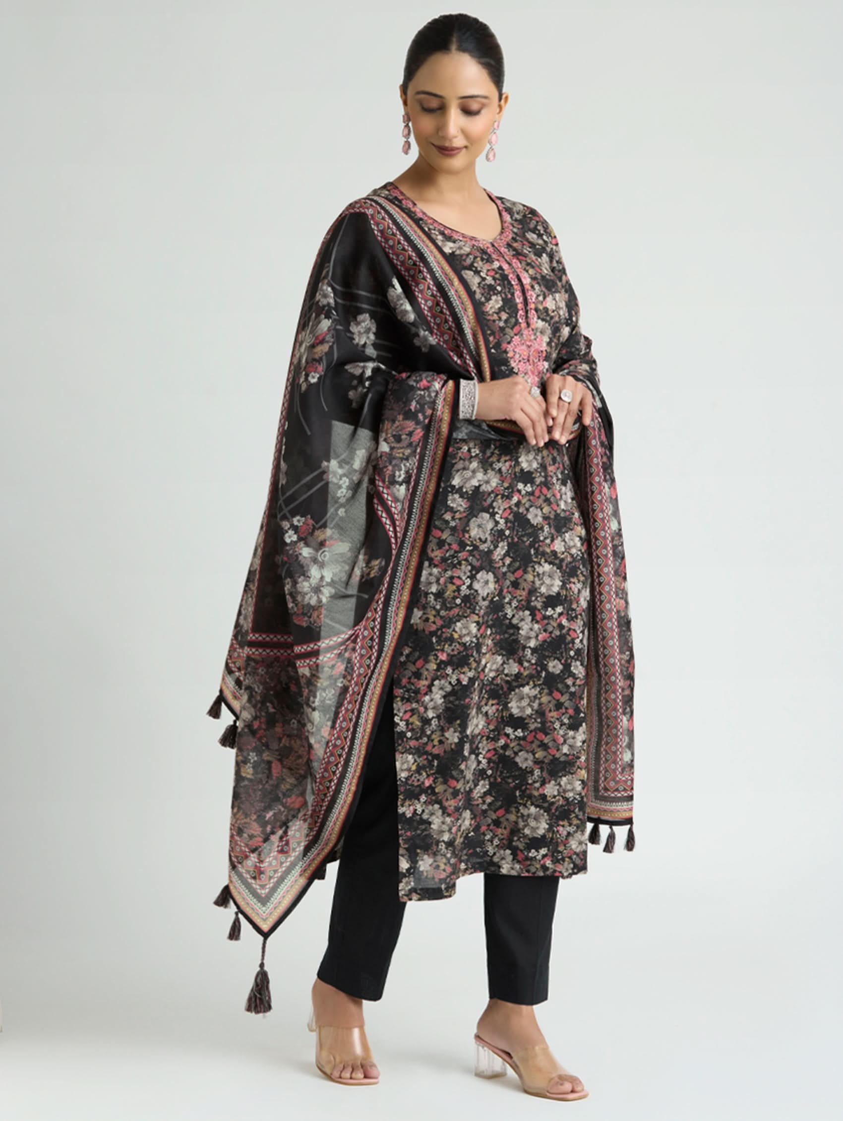 Woman wearing a floral patterned dupatta over a black outfit on a white background