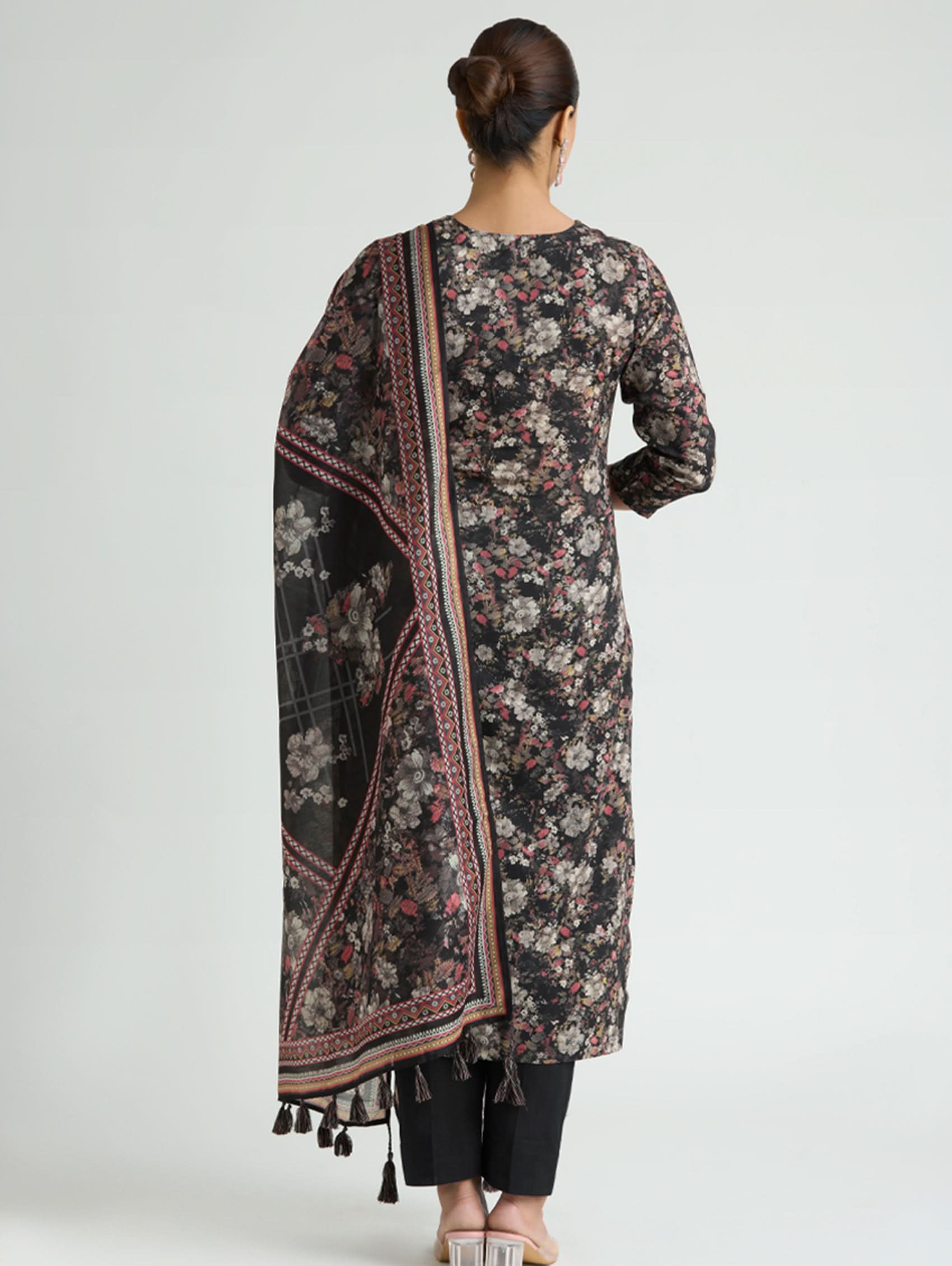 Woman wearing a floral patterned dupatta over her shoulder on a white background