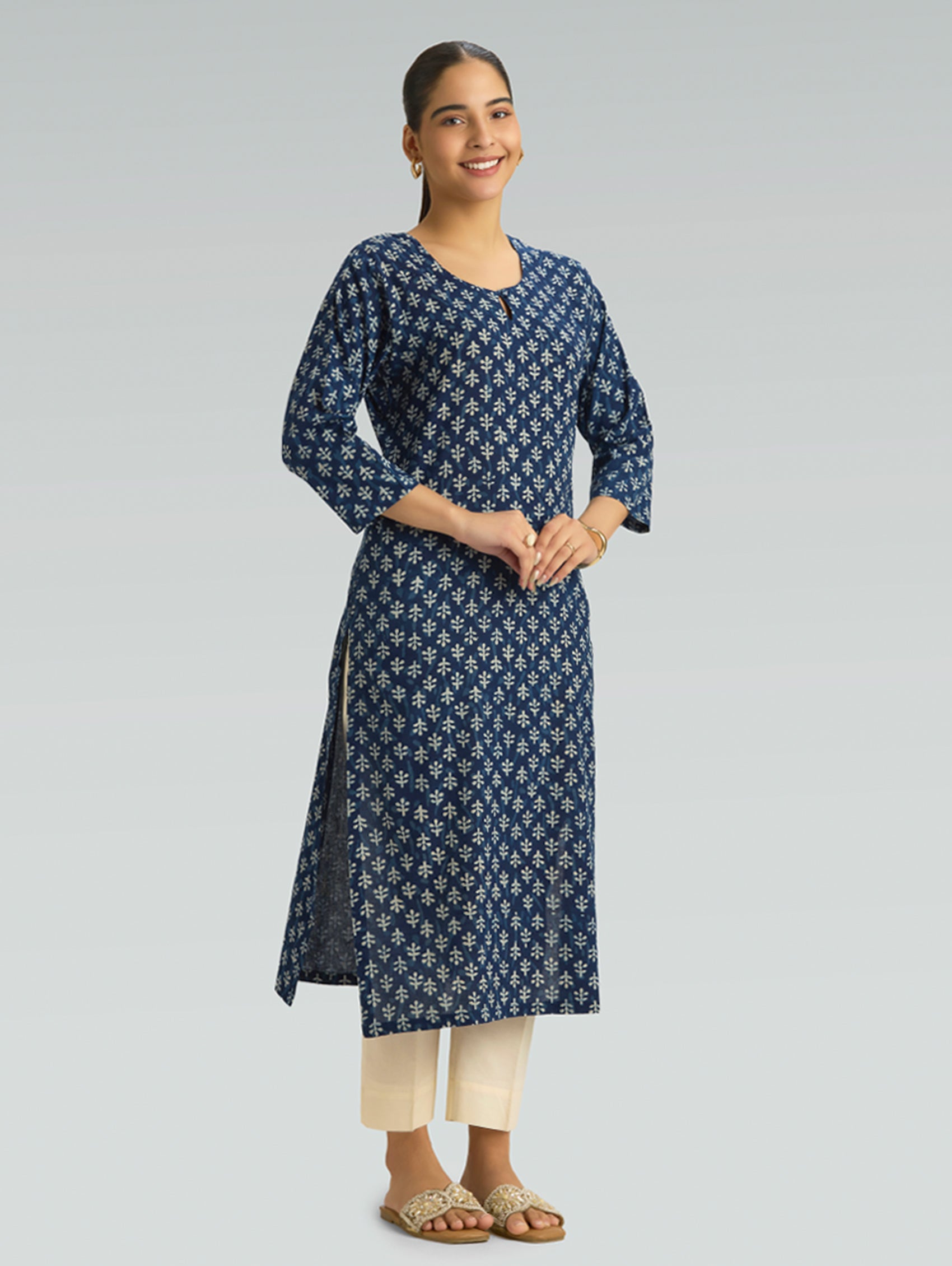 Woman wearing a blue floral patterned kurta on a gray background