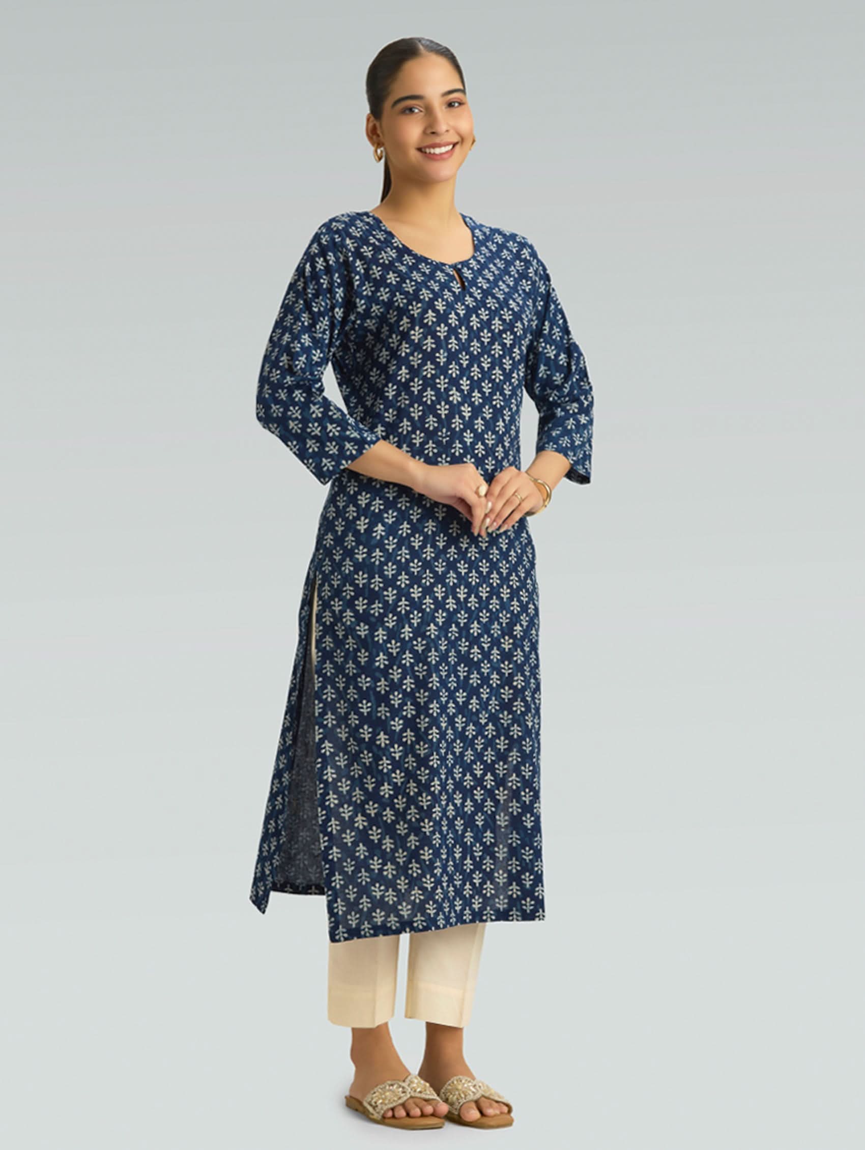 Woman wearing a blue floral patterned kurta on a gray background