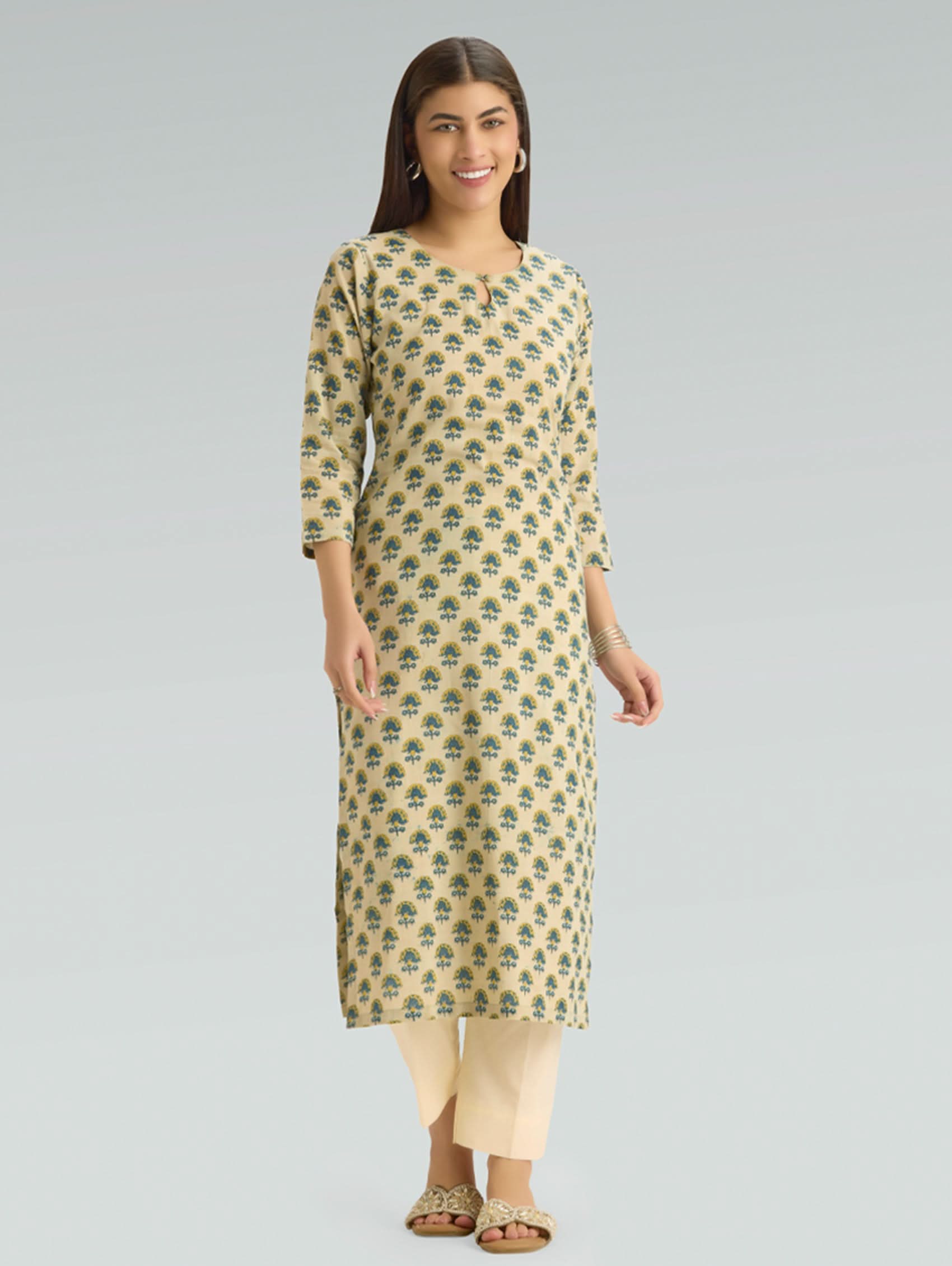 Woman wearing a patterned kurta with beige pants on a gray background