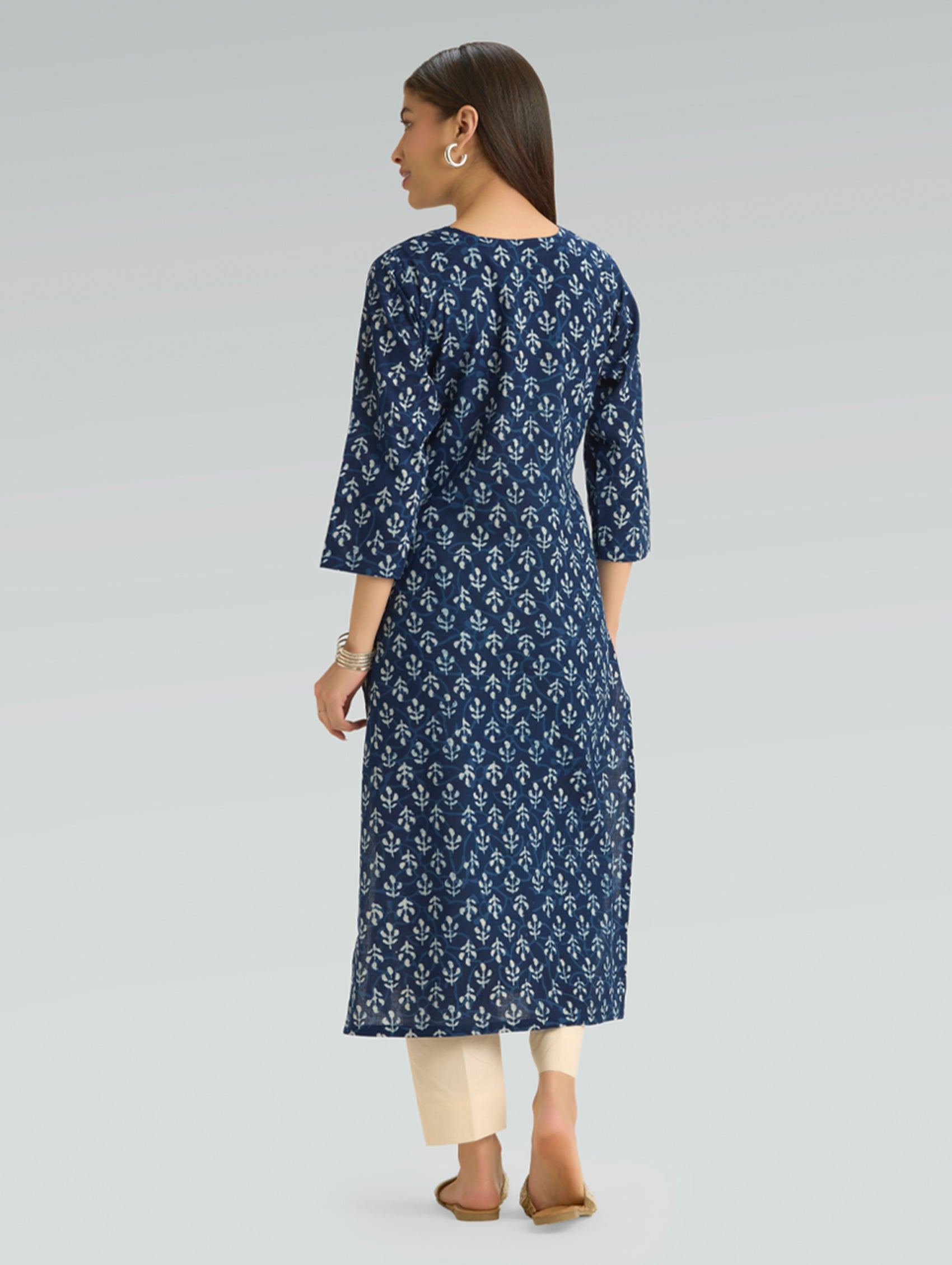 Woman wearing a blue floral dress on a gray background