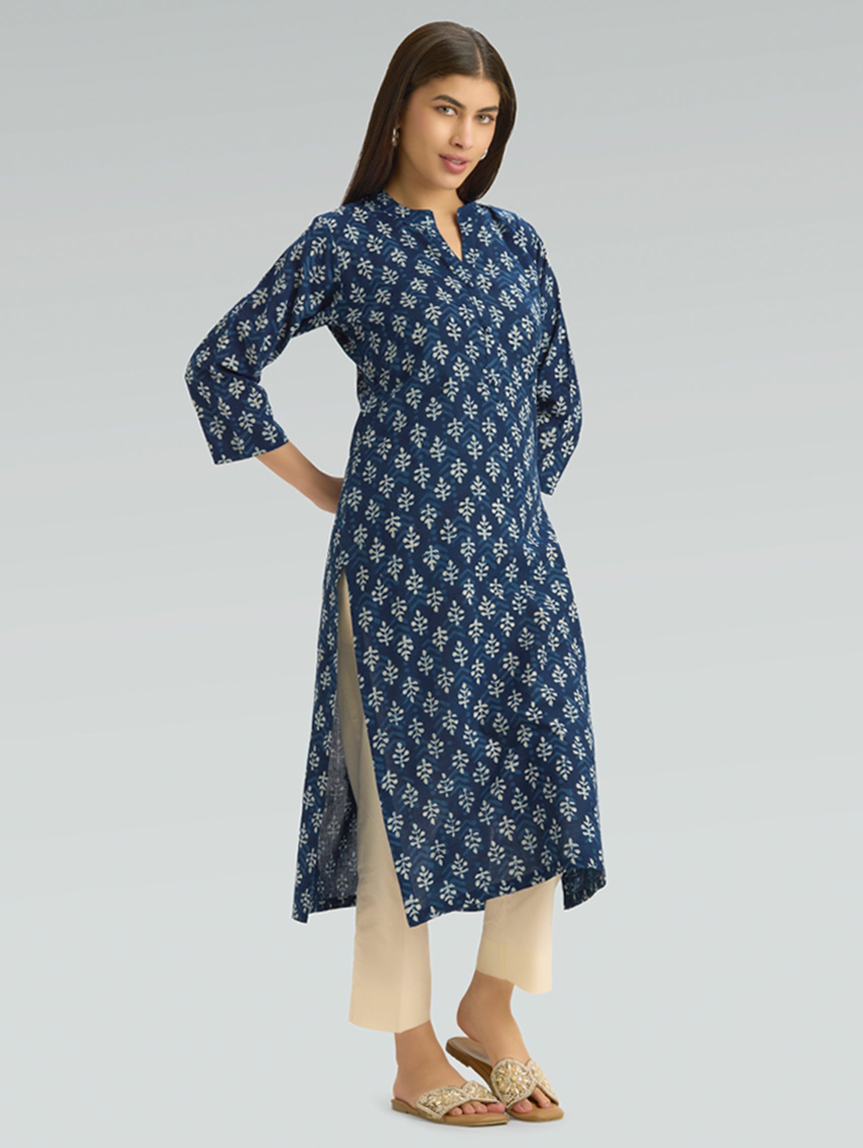 Woman wearing a blue floral patterned dress on a gray background