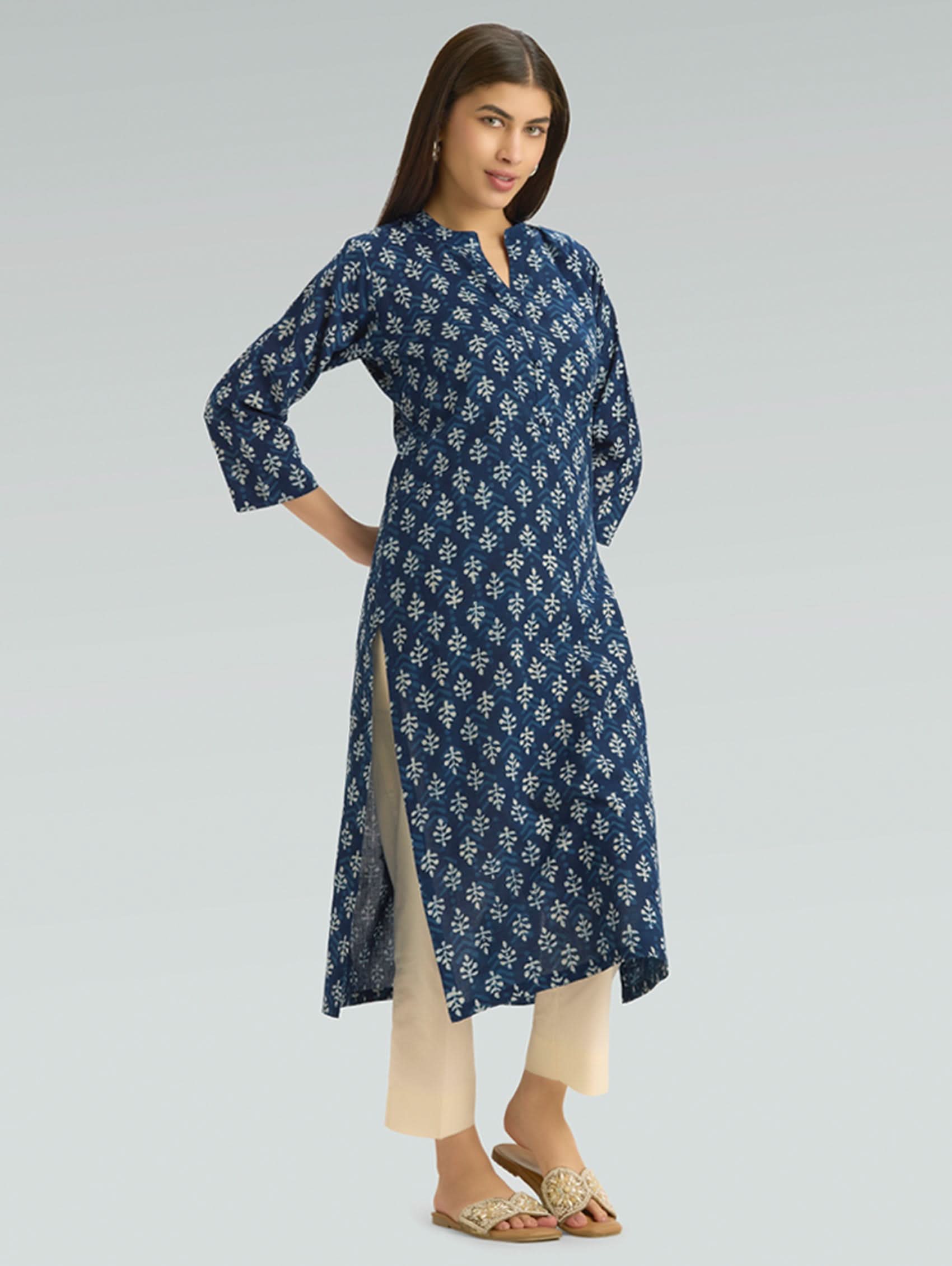 Woman wearing a blue floral patterned dress on a gray background