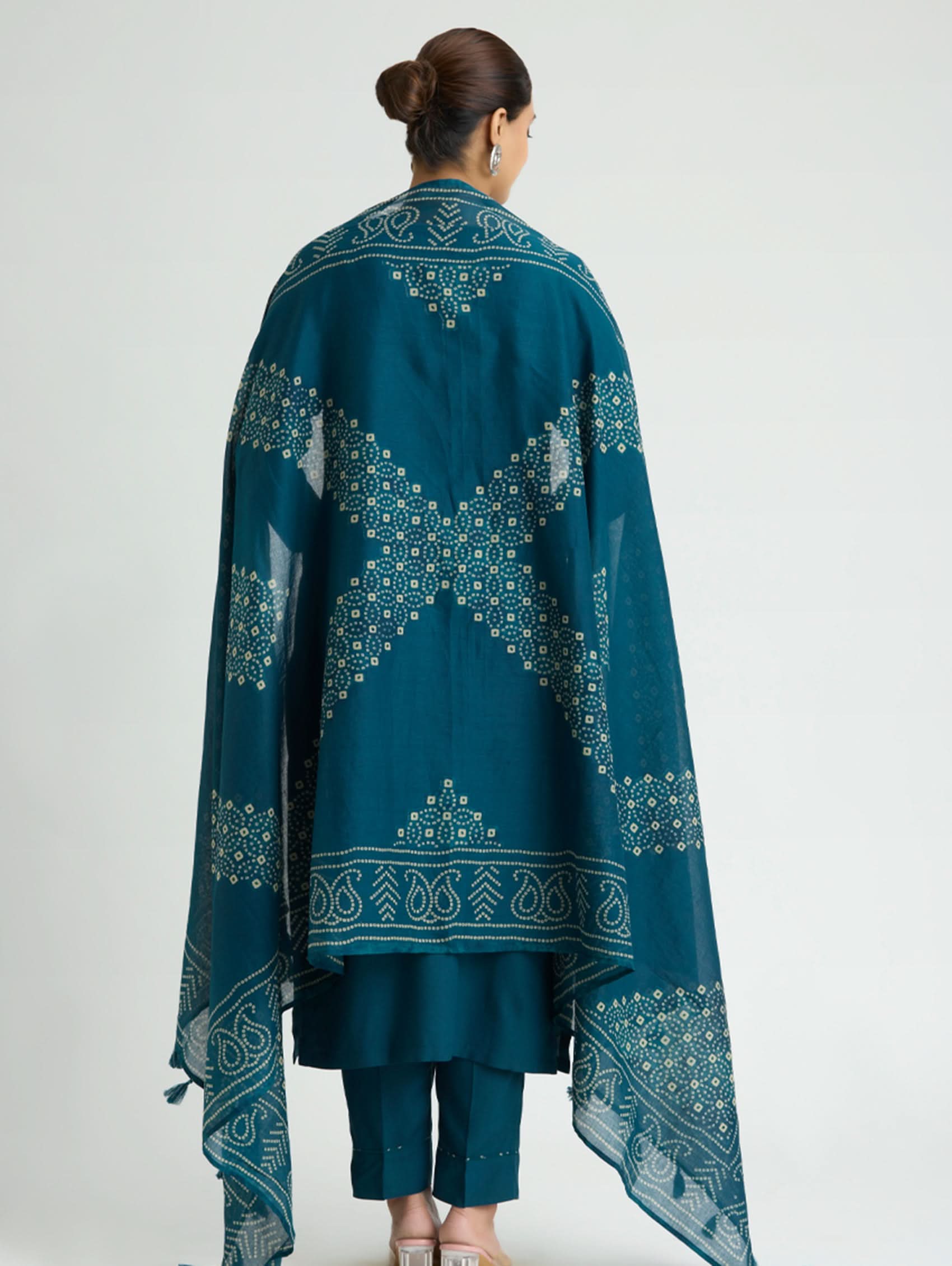 Teal embroidered traditional outfit with a plain background