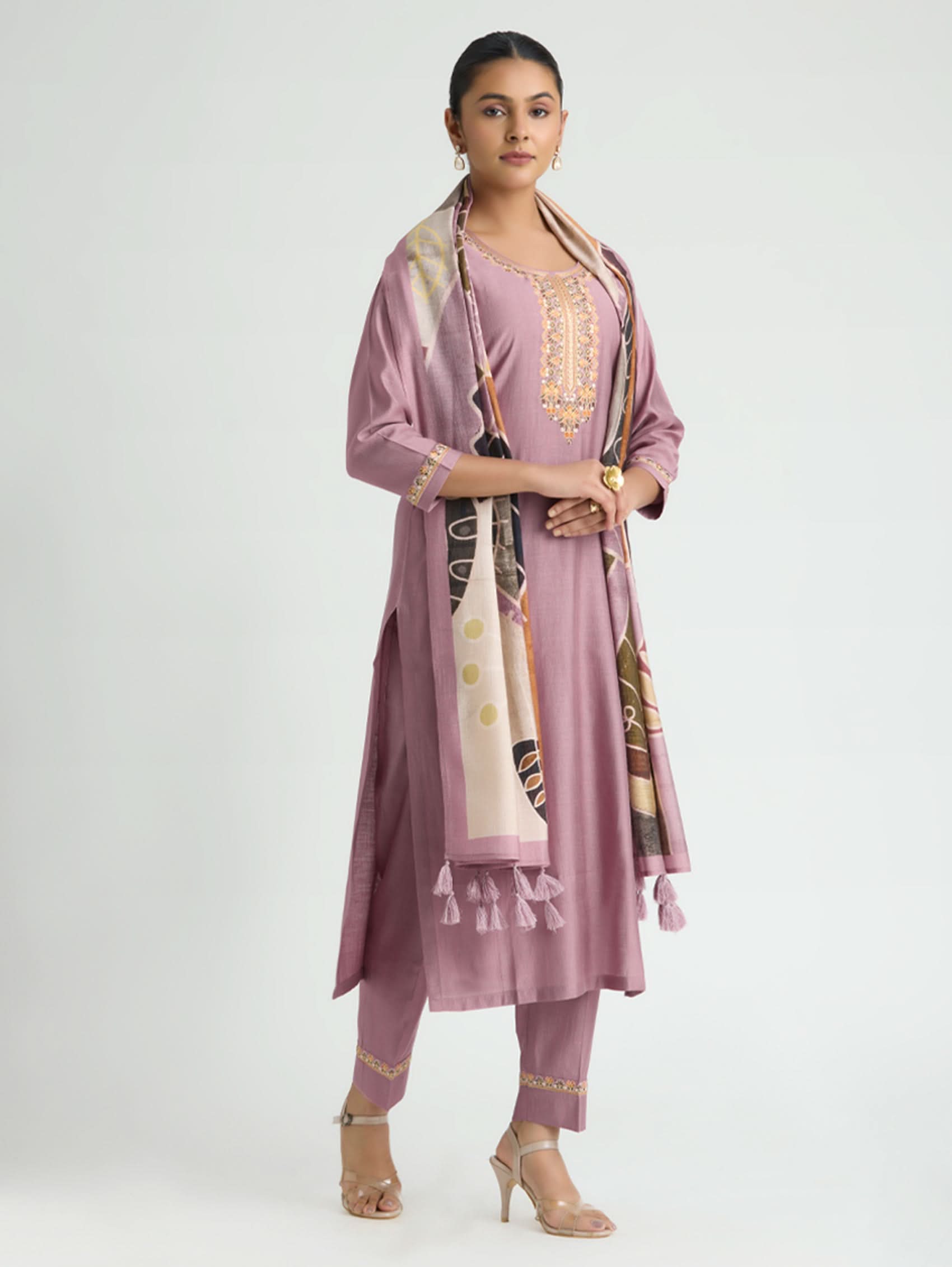 Woman wearing a mauve outfit with a matching dupatta on a white background