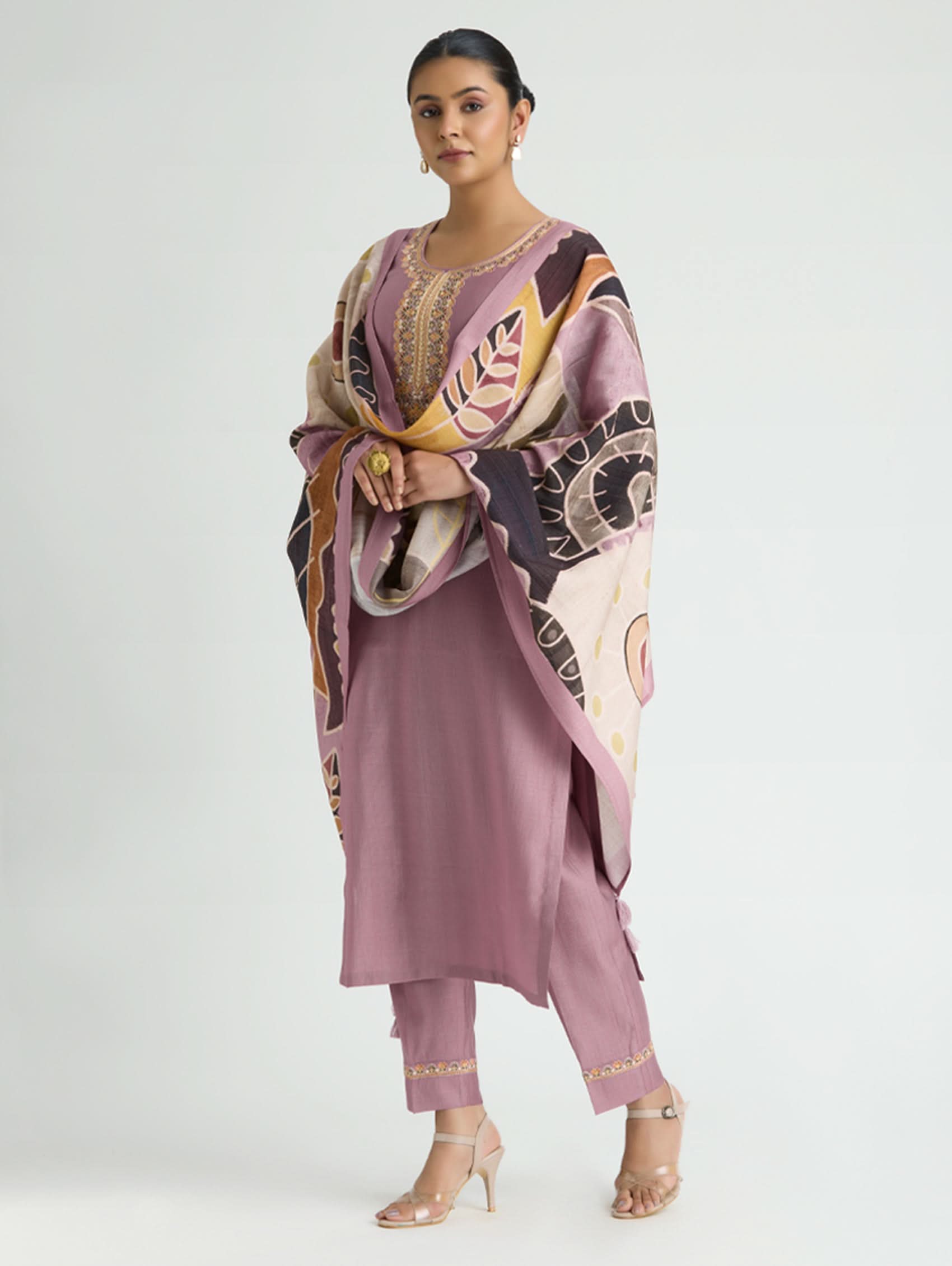 Woman wearing a pink outfit with a patterned dupatta on a white background