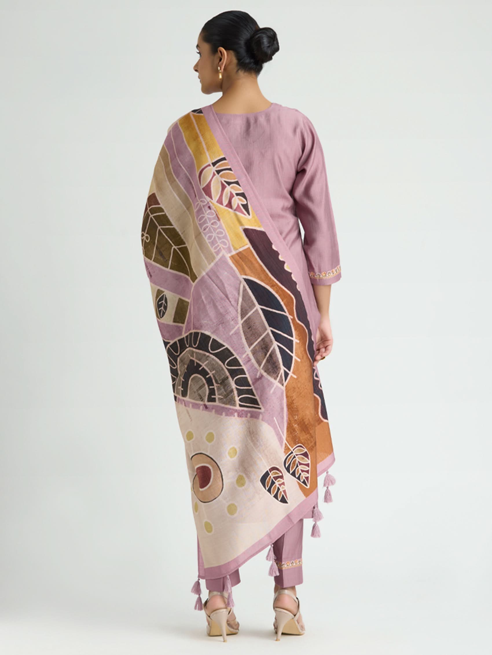 Woman wearing a long, patterned dress with a white background