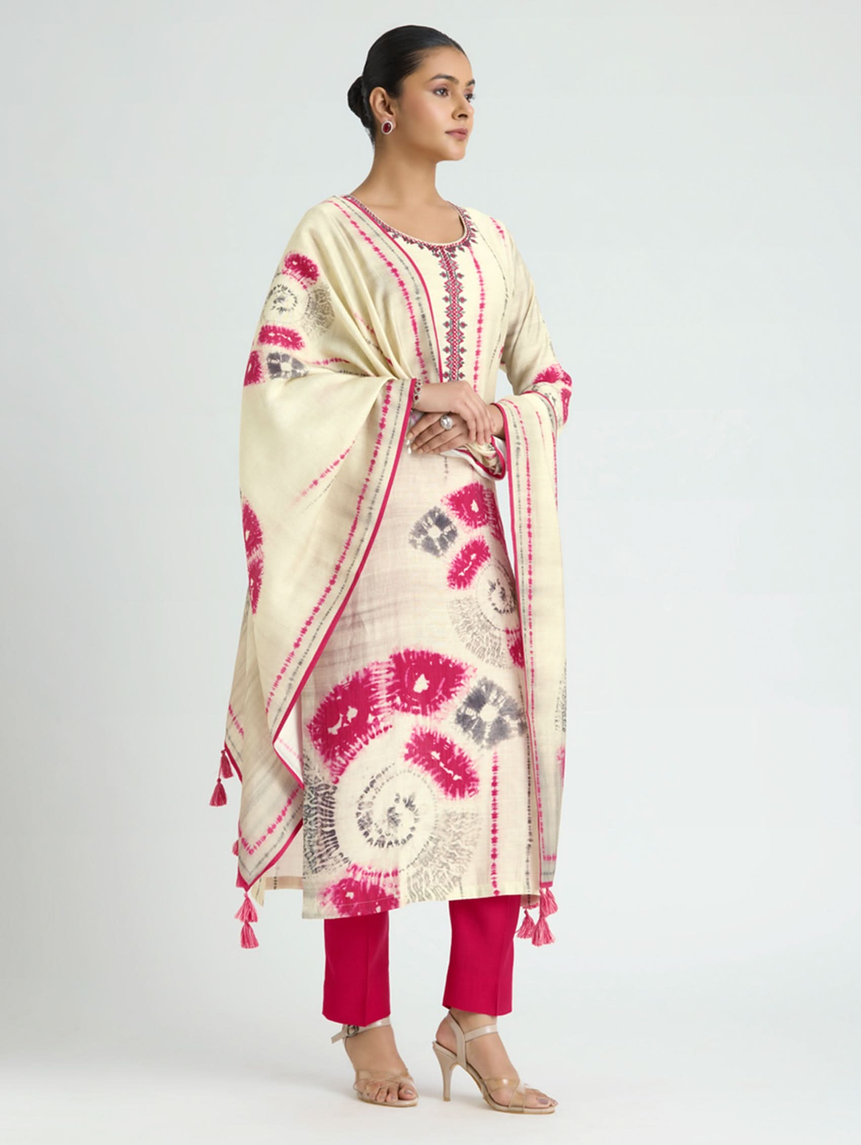 Woman wearing a cream and pink traditional outfit with a matching dupatta on a white background