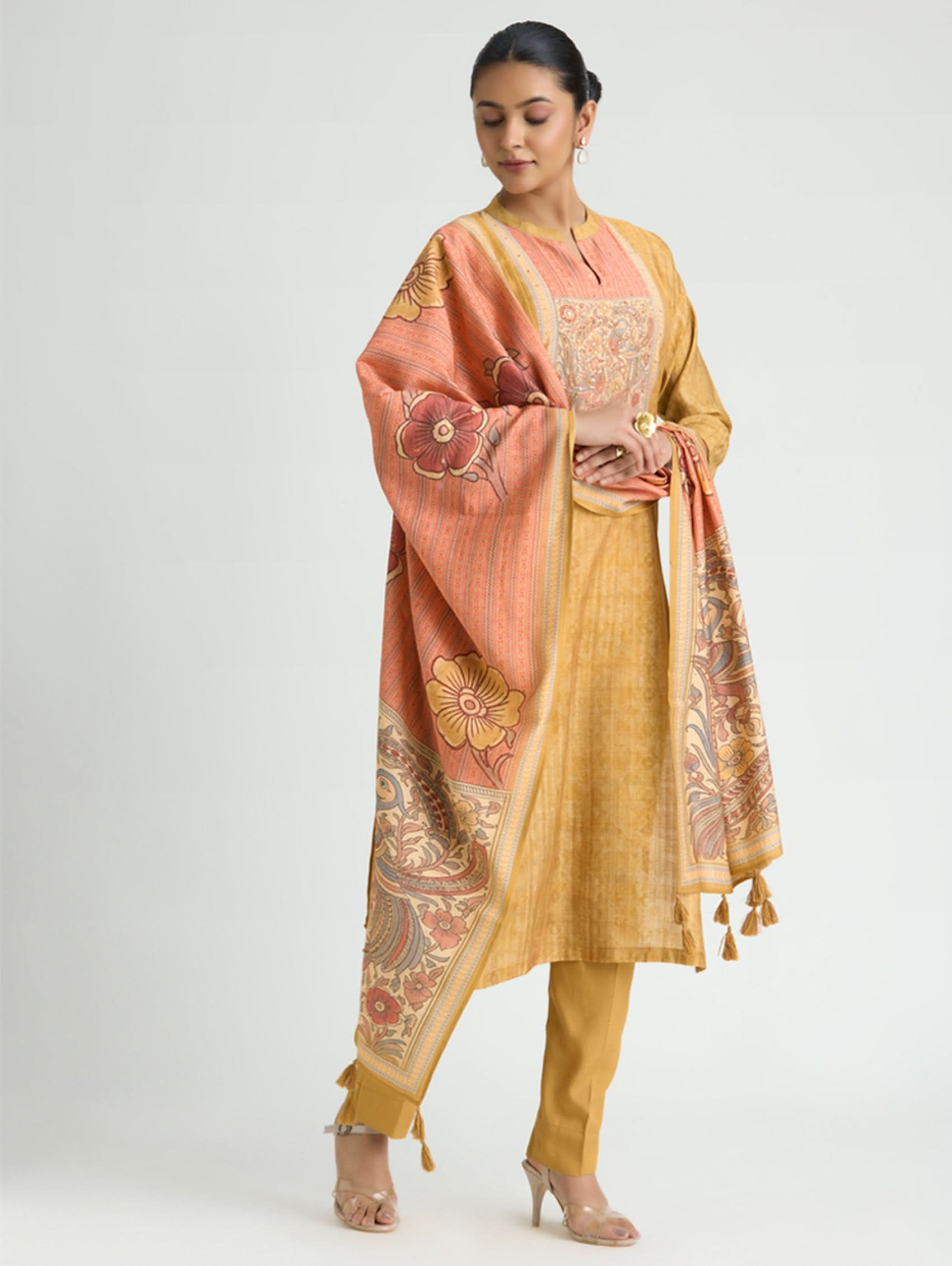 Woman wearing a traditional outfit with a floral dupatta on a white background