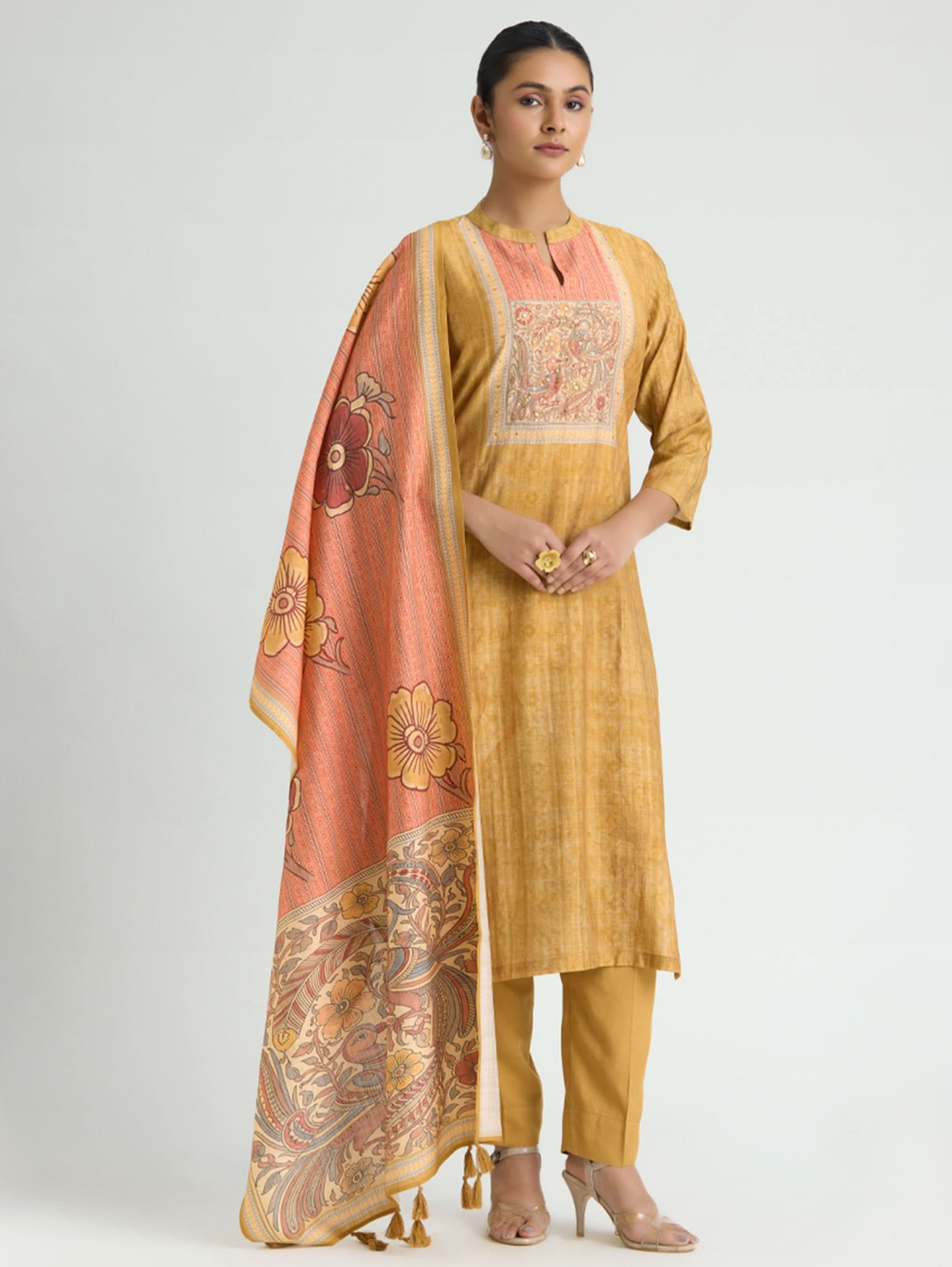 Woman wearing a yellow kurta with a matching dupatta on a white background
