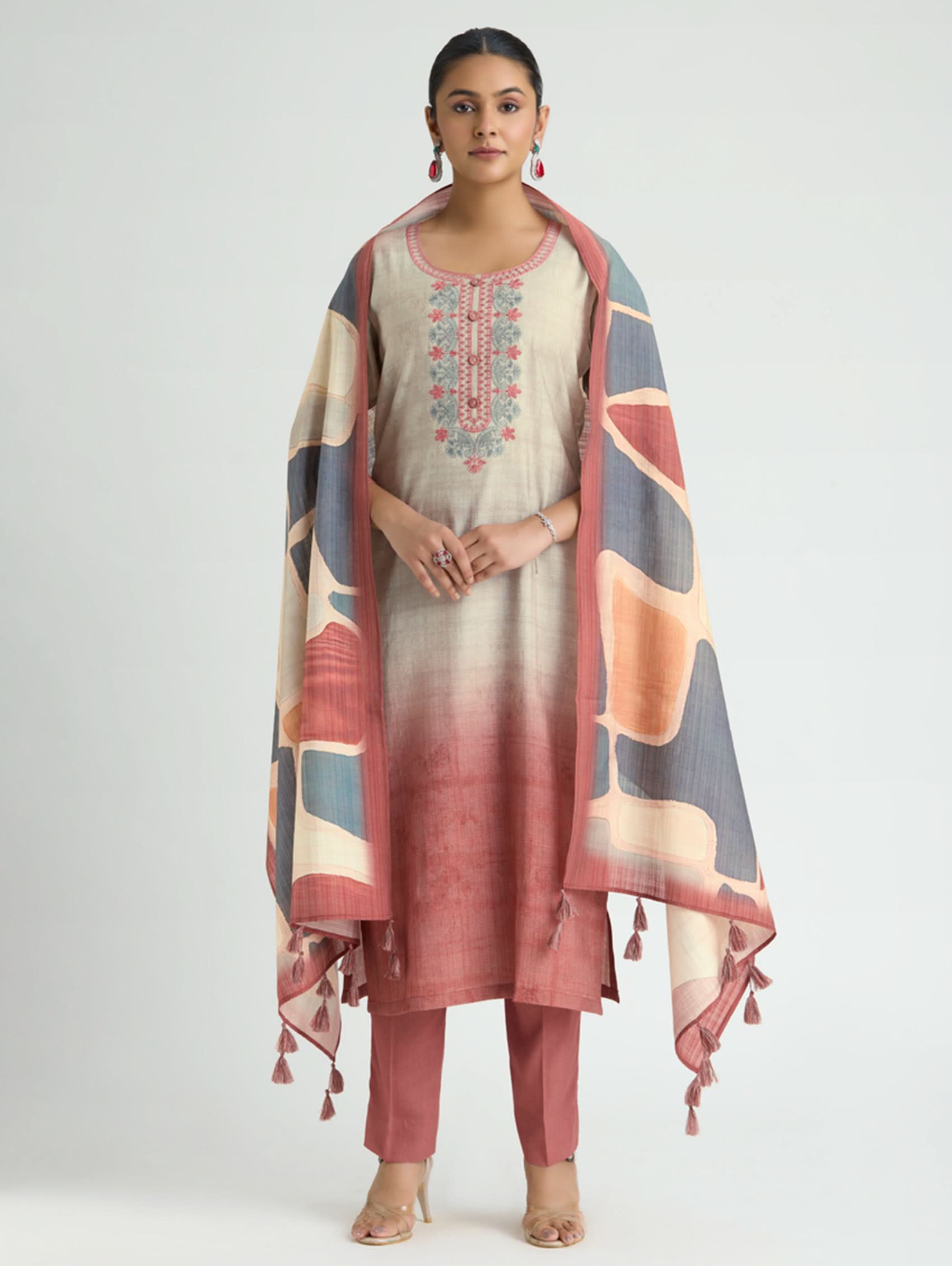 Woman wearing a traditional outfit with a patterned dupatta on a white background