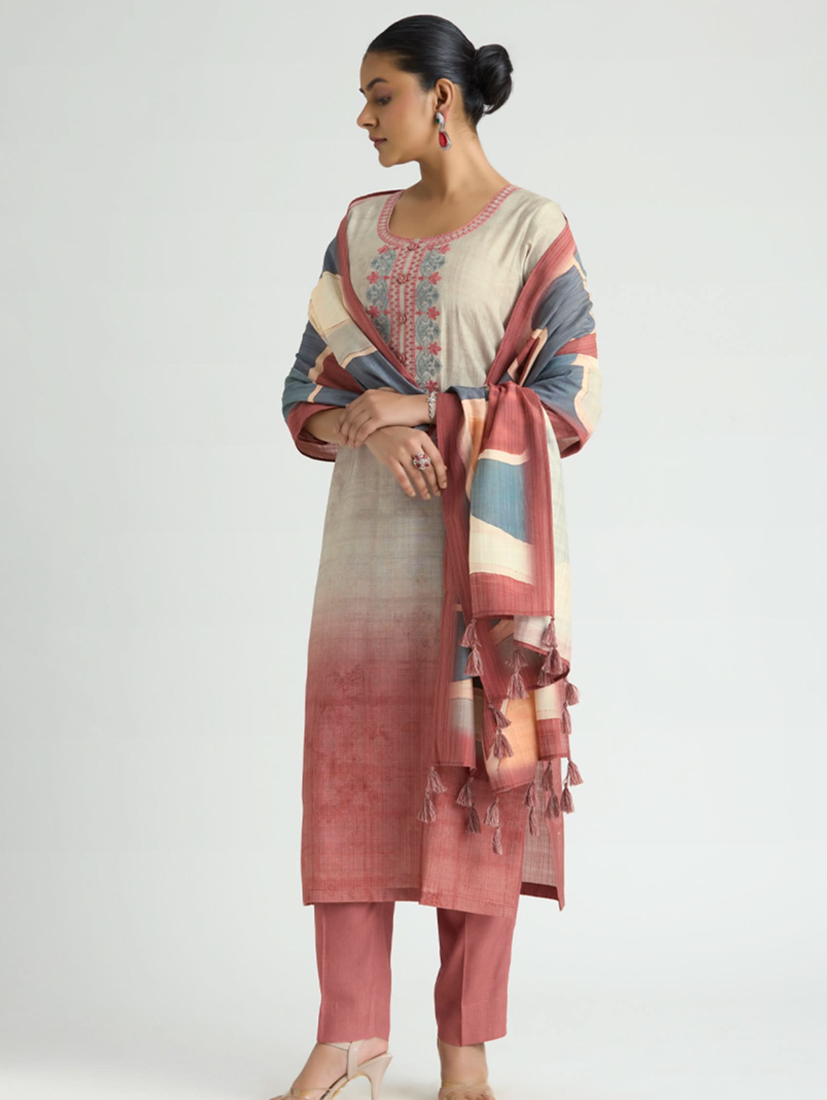 Woman wearing a traditional outfit with a colorful dupatta on a white background