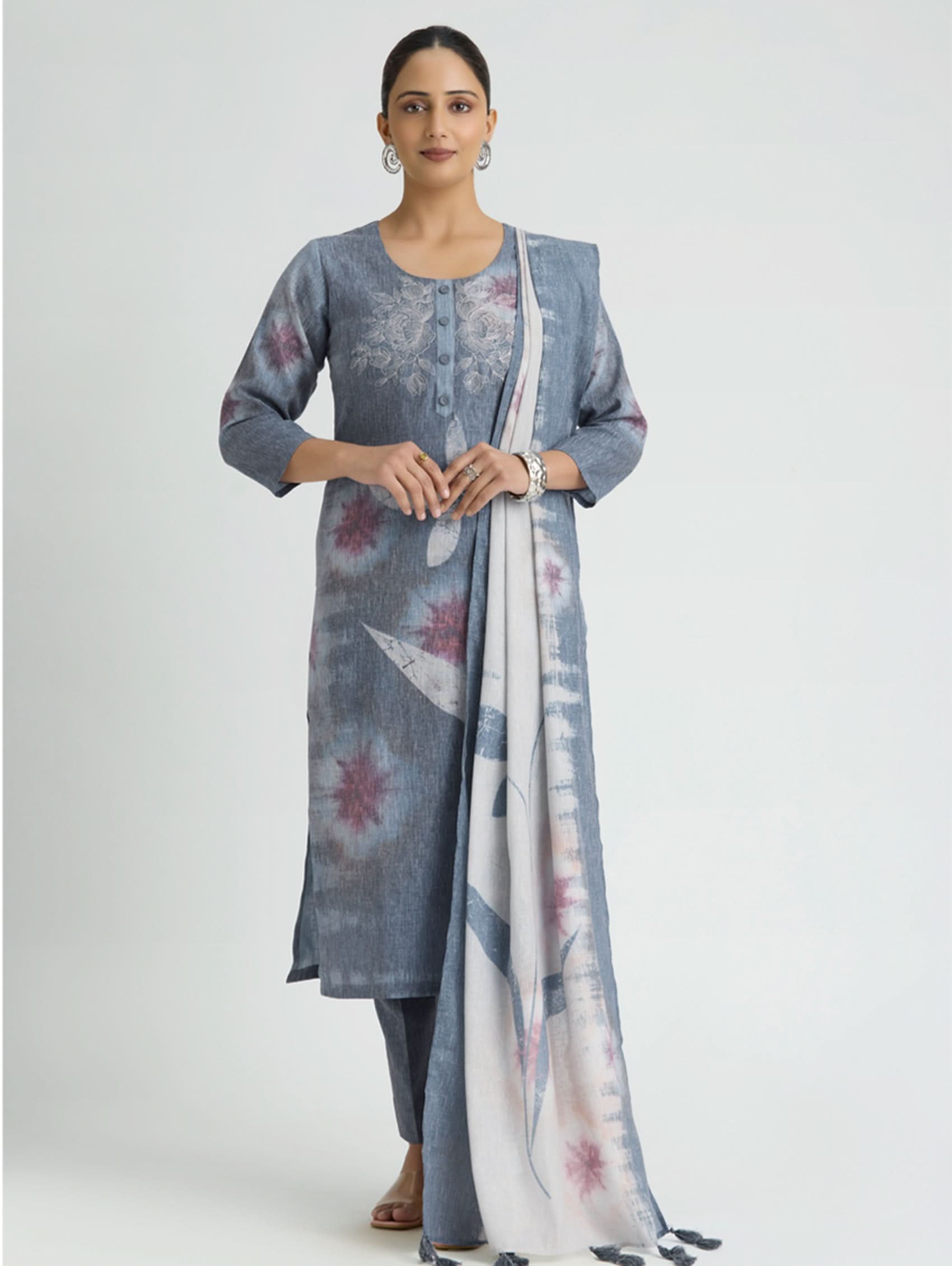 Woman wearing a blue floral kurta with a matching dupatta on a white background