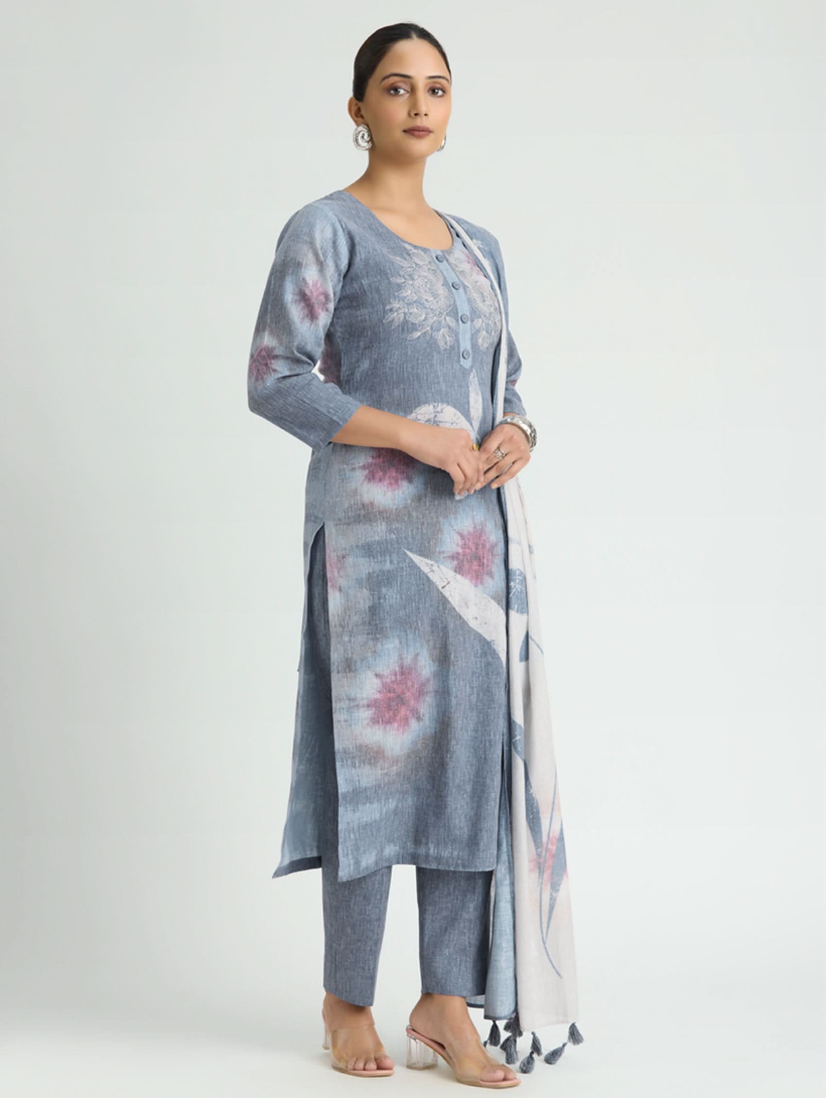 Woman wearing a blue floral kurta with pants and a dupatta on a white background