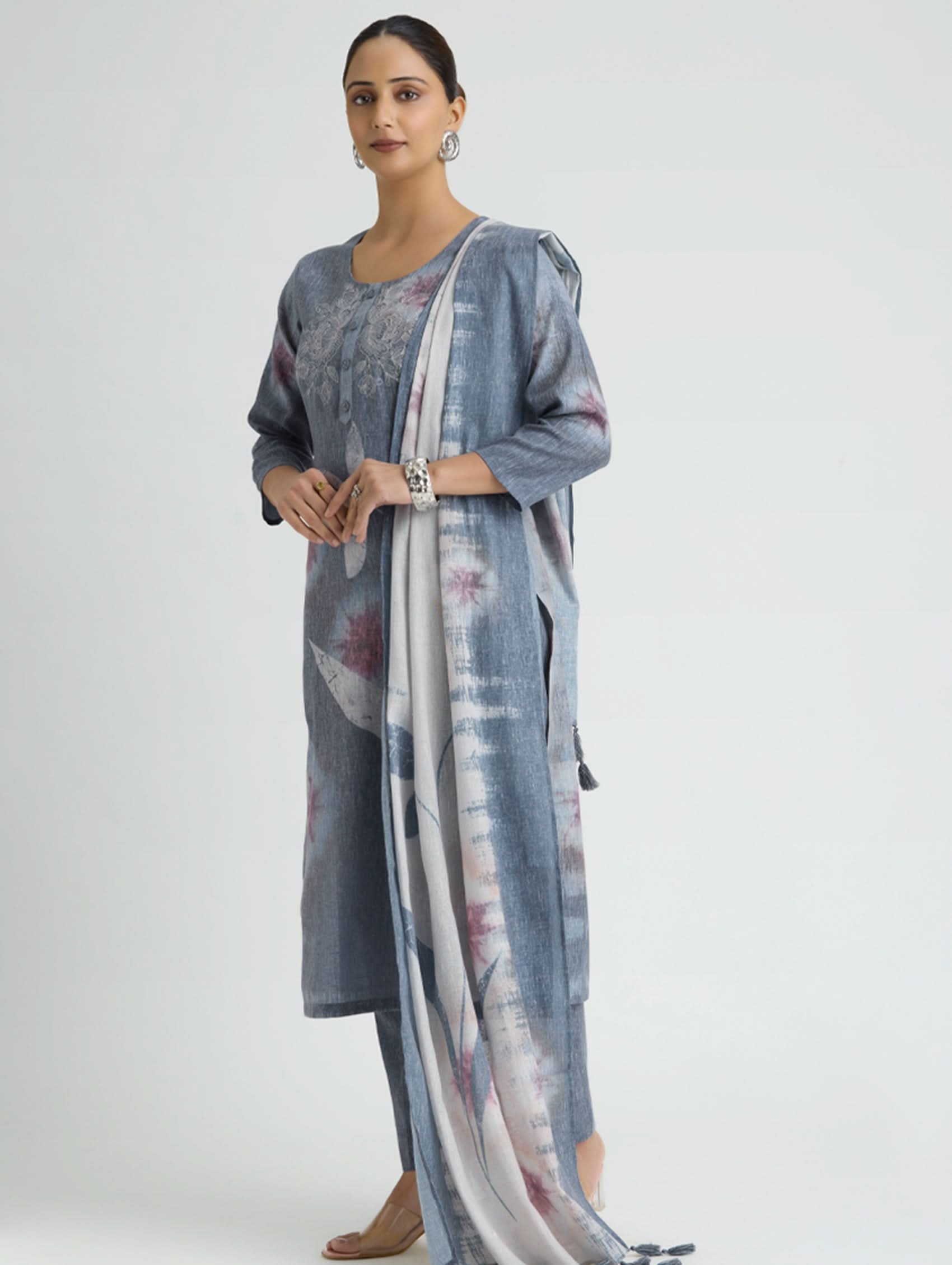 Woman wearing a long, light blue floral-patterned dress with a matching dupatta on a white background