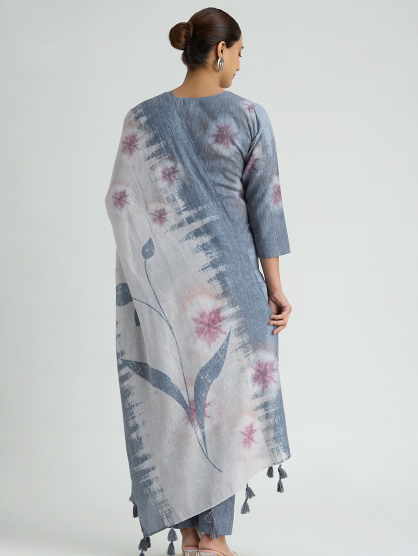 Woman wearing a floral patterned kurta with a plain background