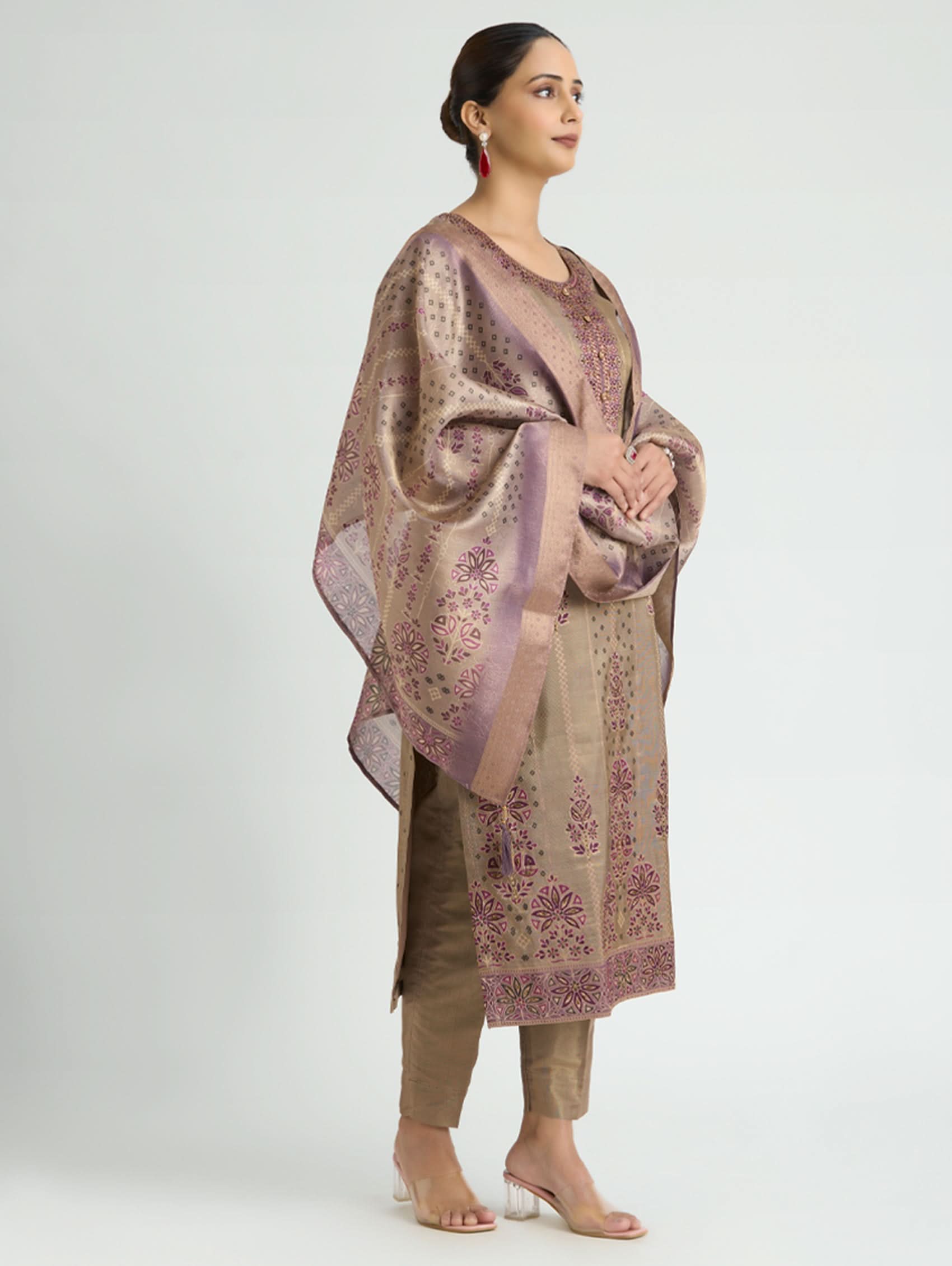 Woman wearing a patterned shawl over a long dress on a white background
