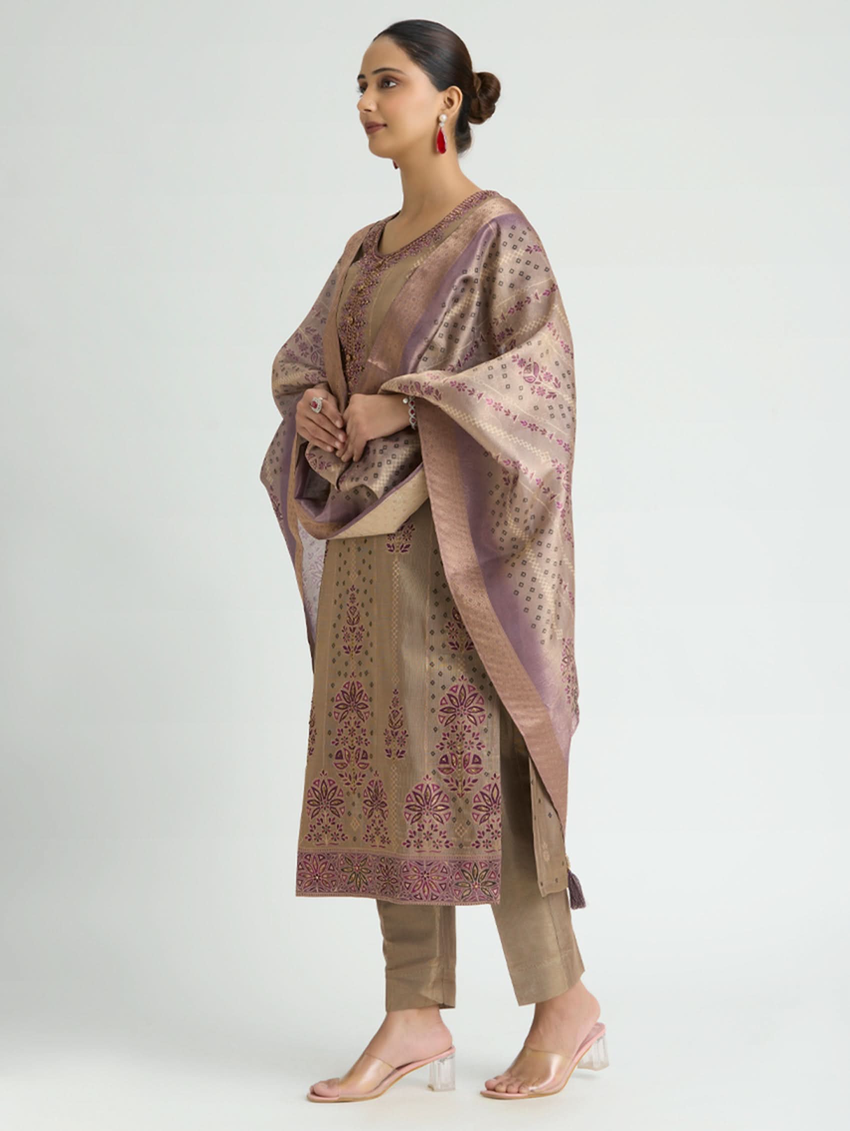 Woman wearing a traditional outfit with a patterned dupatta on a white background