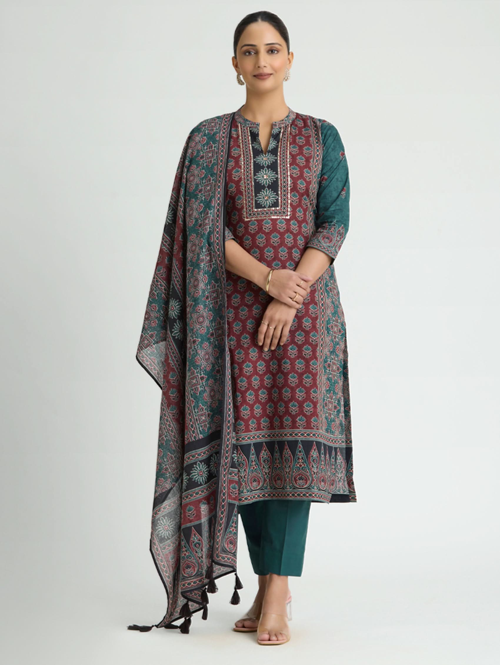 Woman wearing a traditional outfit with a patterned dupatta on a white background