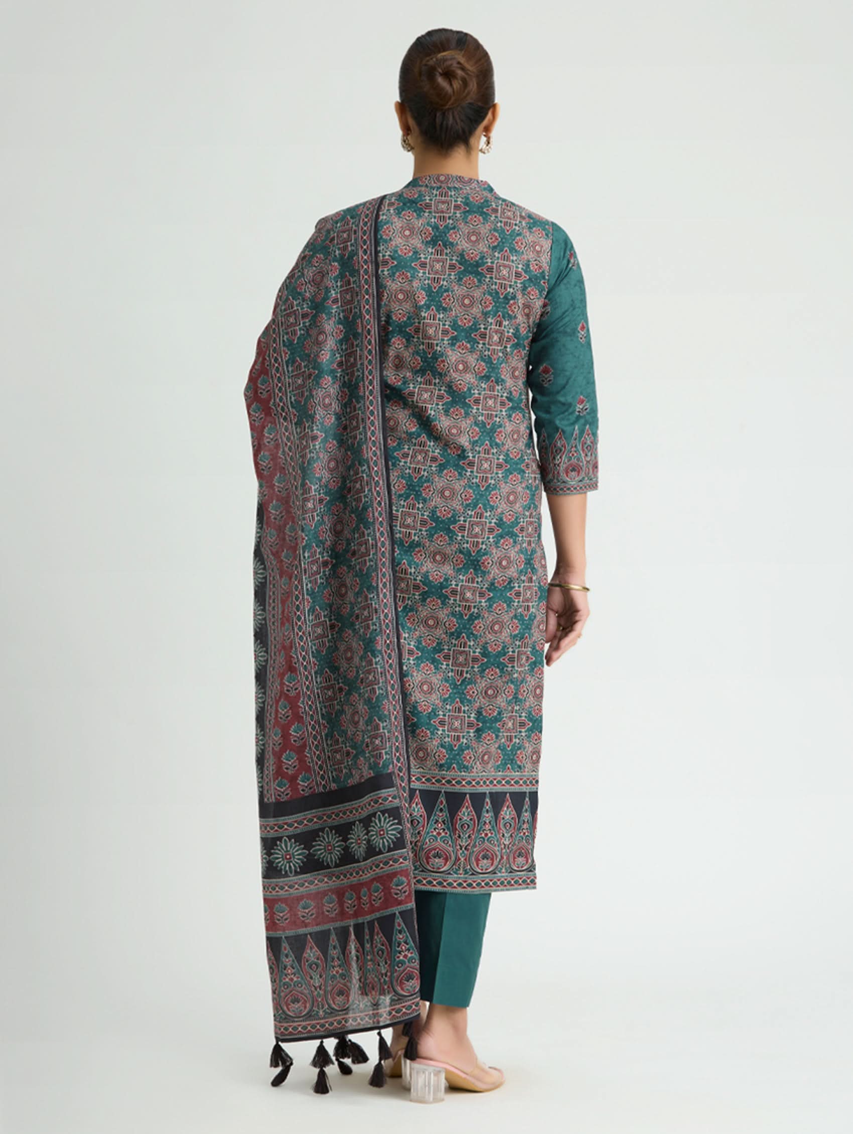 Woman wearing a patterned kurta with a matching dupatta on a white background