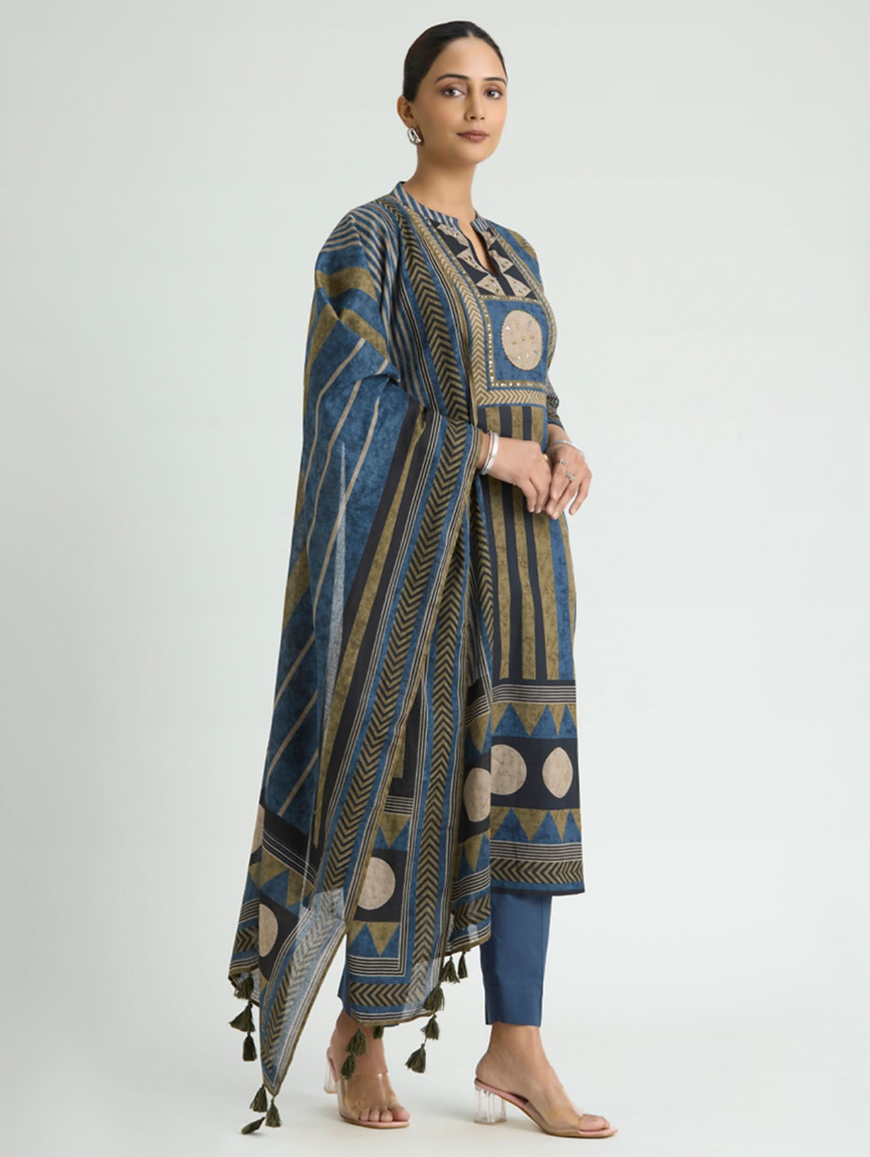 Woman wearing a blue and brown patterned dress with a white background