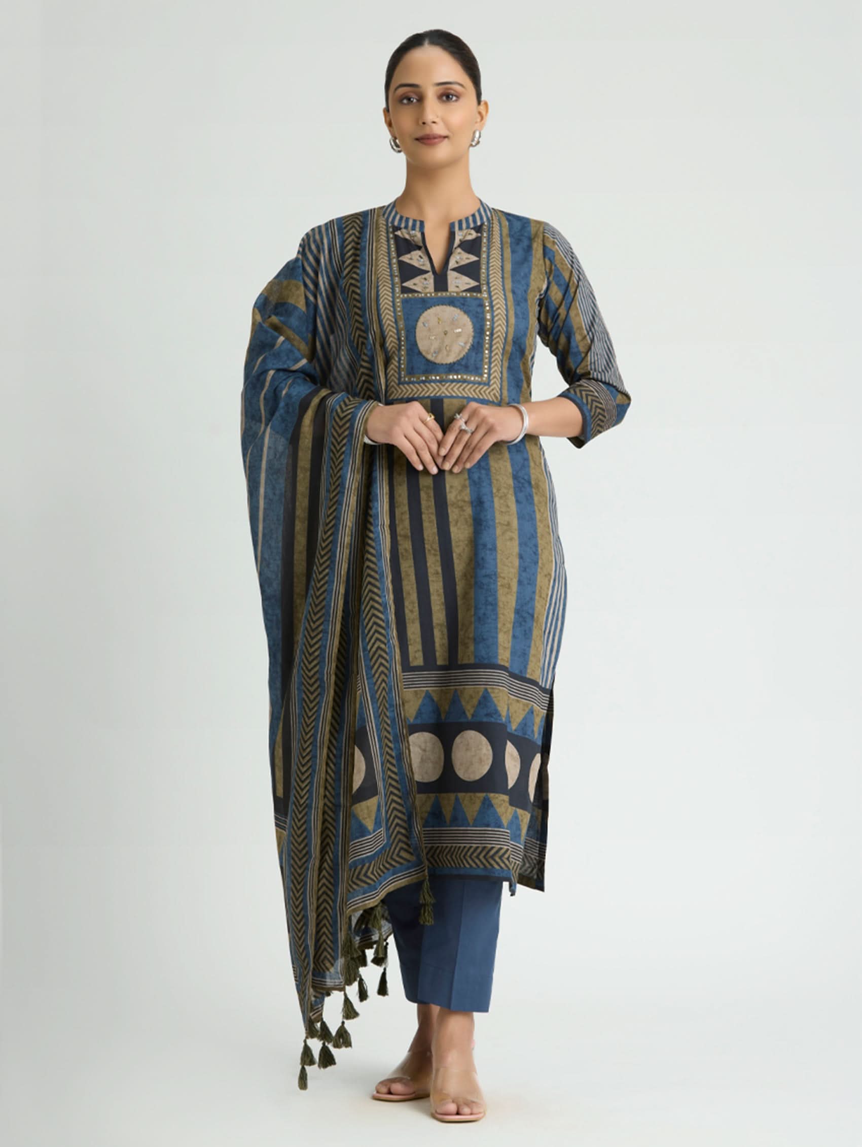 Woman wearing a patterned blue and brown dress with a plain background