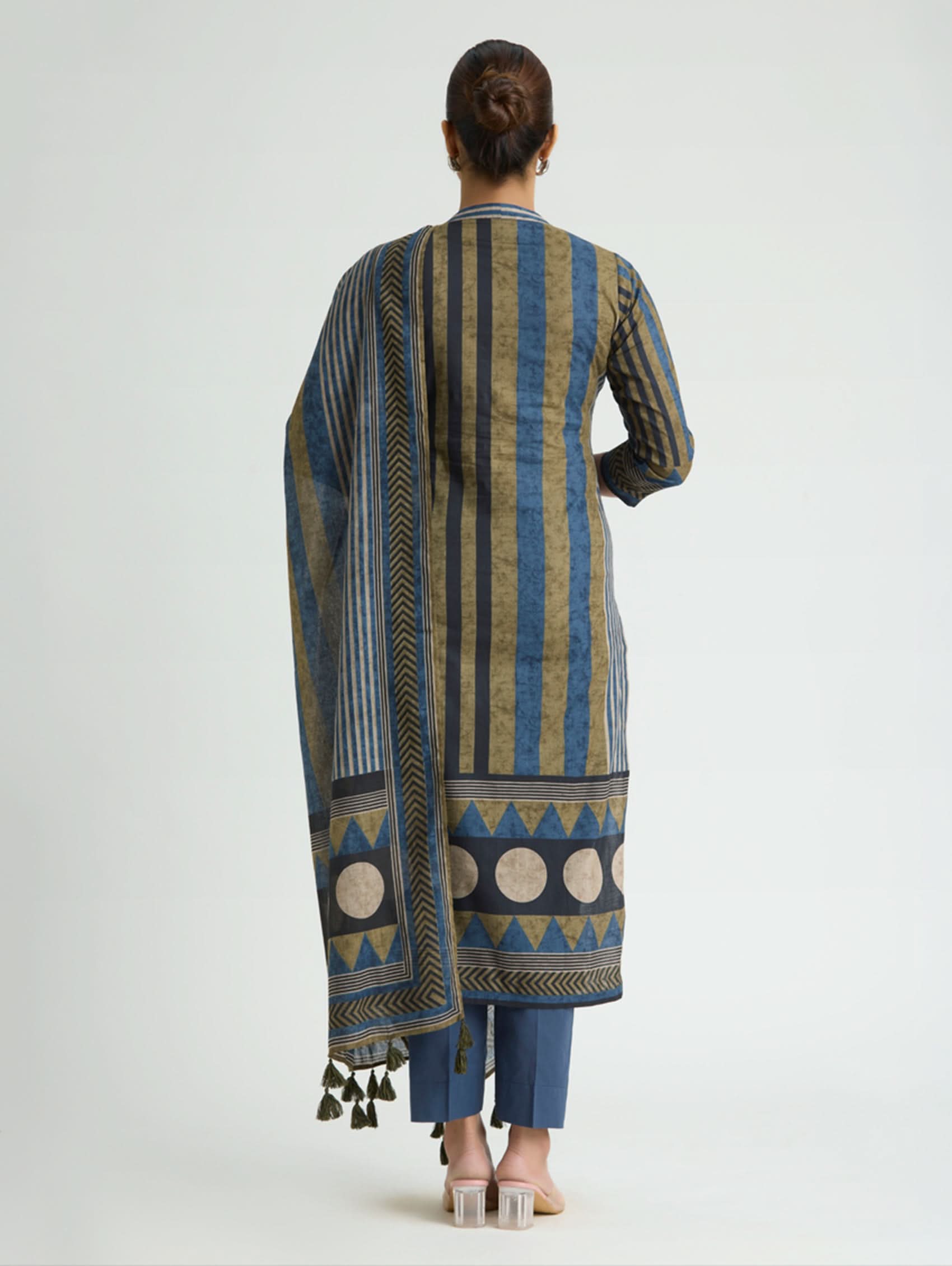 Woman wearing a patterned kurta with a matching dupatta on a white background