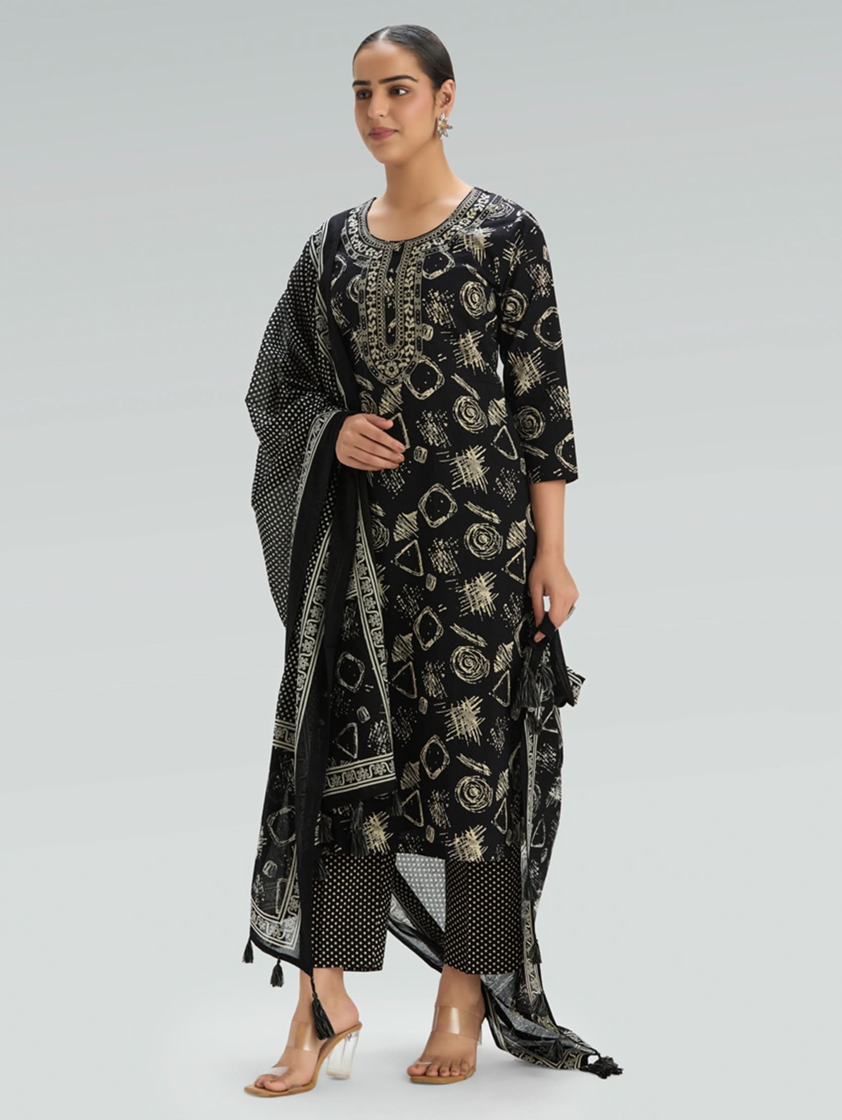 Woman wearing a Black outfit with a patterned Dupatta on a light gray background