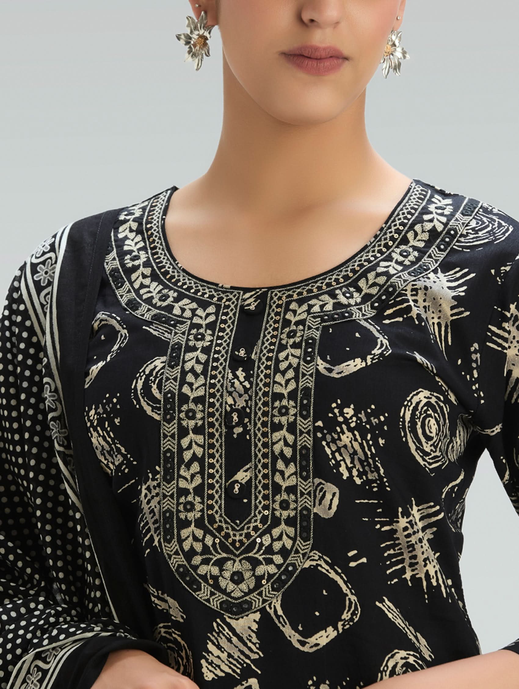 Woman wearing a Black outfit with a patterned Dupatta on a light gray background