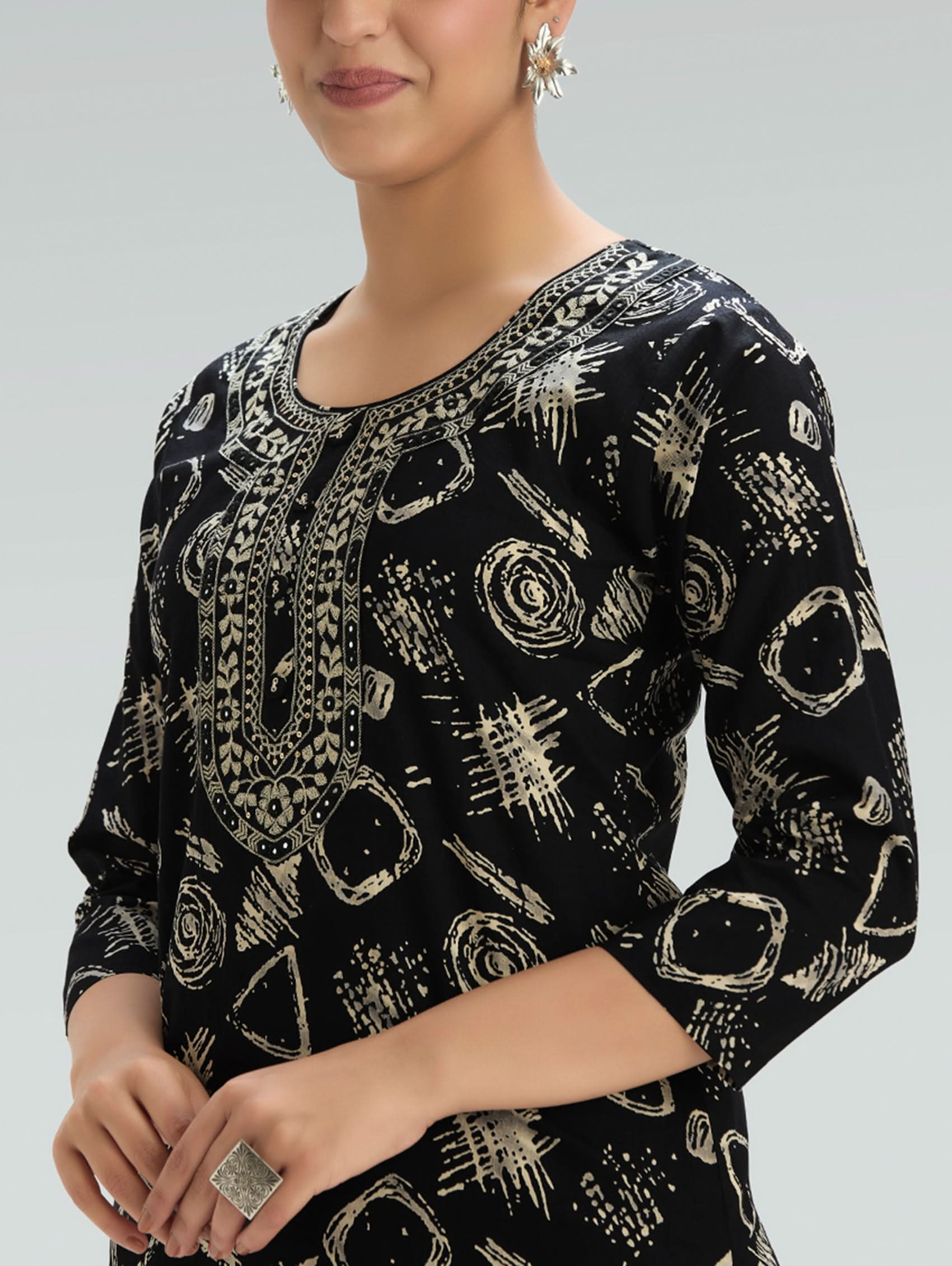 Woman wearing a Black outfit with a patterned Dupatta on a light gray background