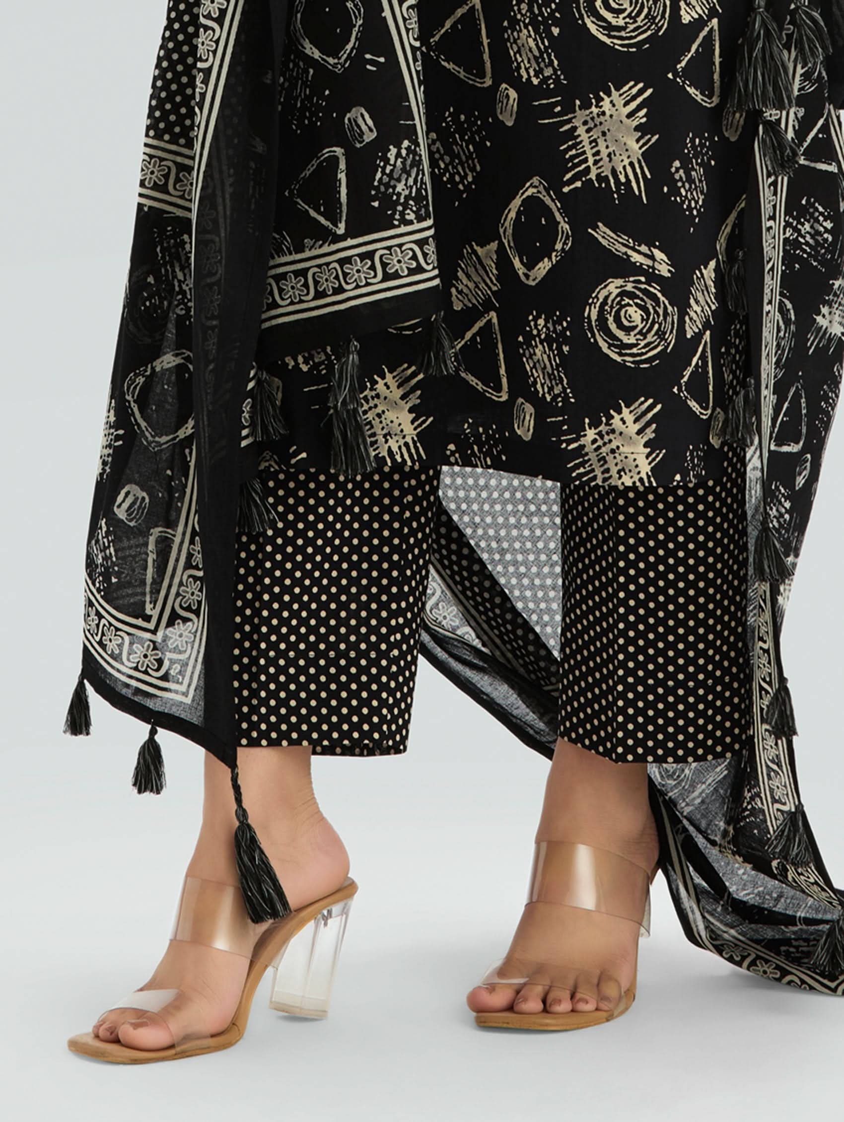 Woman wearing a Black outfit with a patterned Dupatta on a light gray background