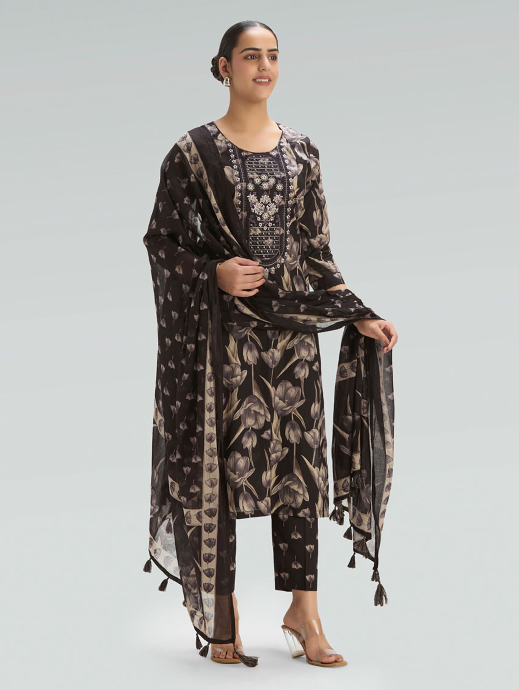 Woman wearing a floral patterned outfit with a Dupatta on a light gray background