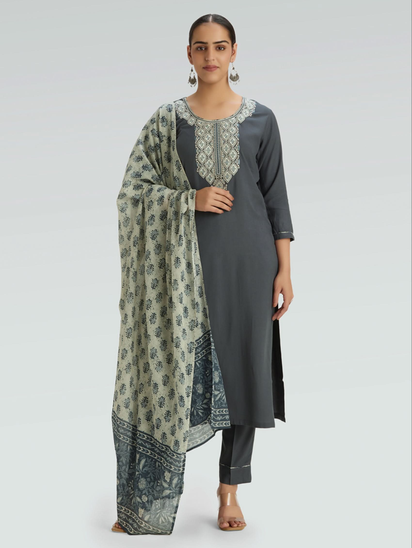 Woman wearing a gray outfit with a patterned Dupatta on a light gray background