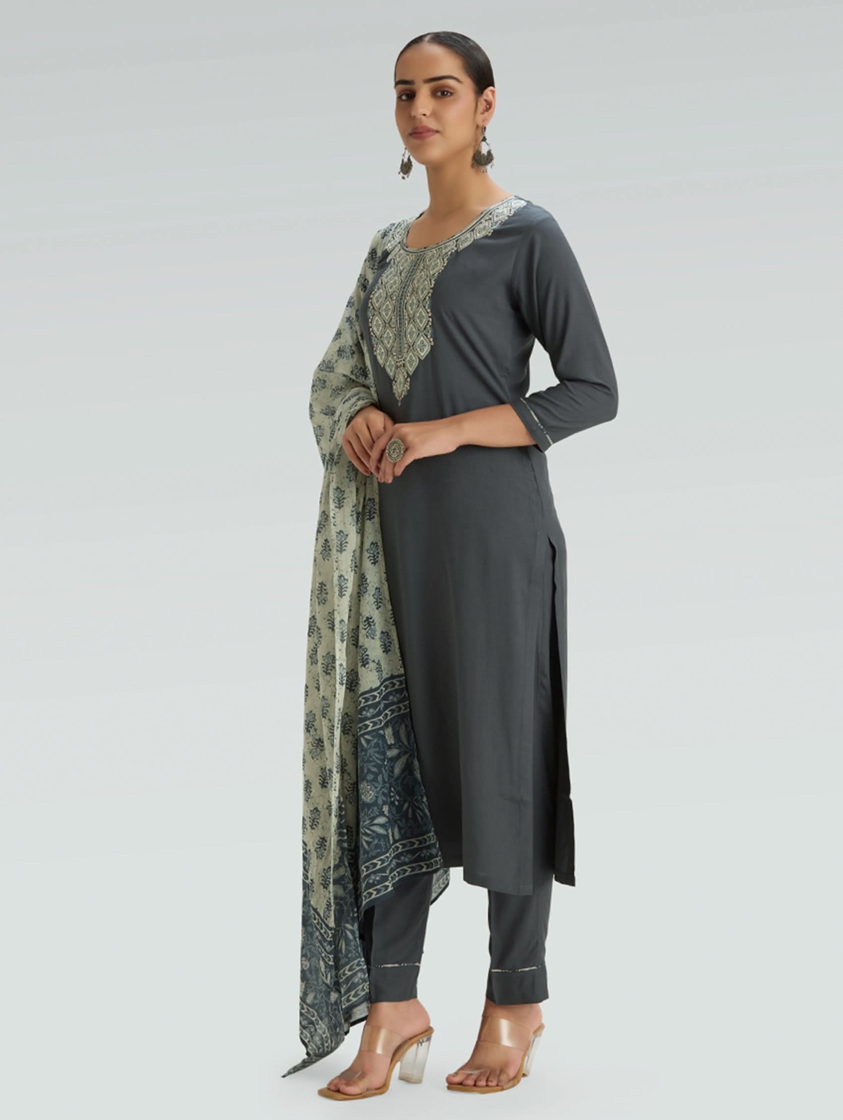 Woman wearing a gray outfit with a patterned Dupatta on a light gray background