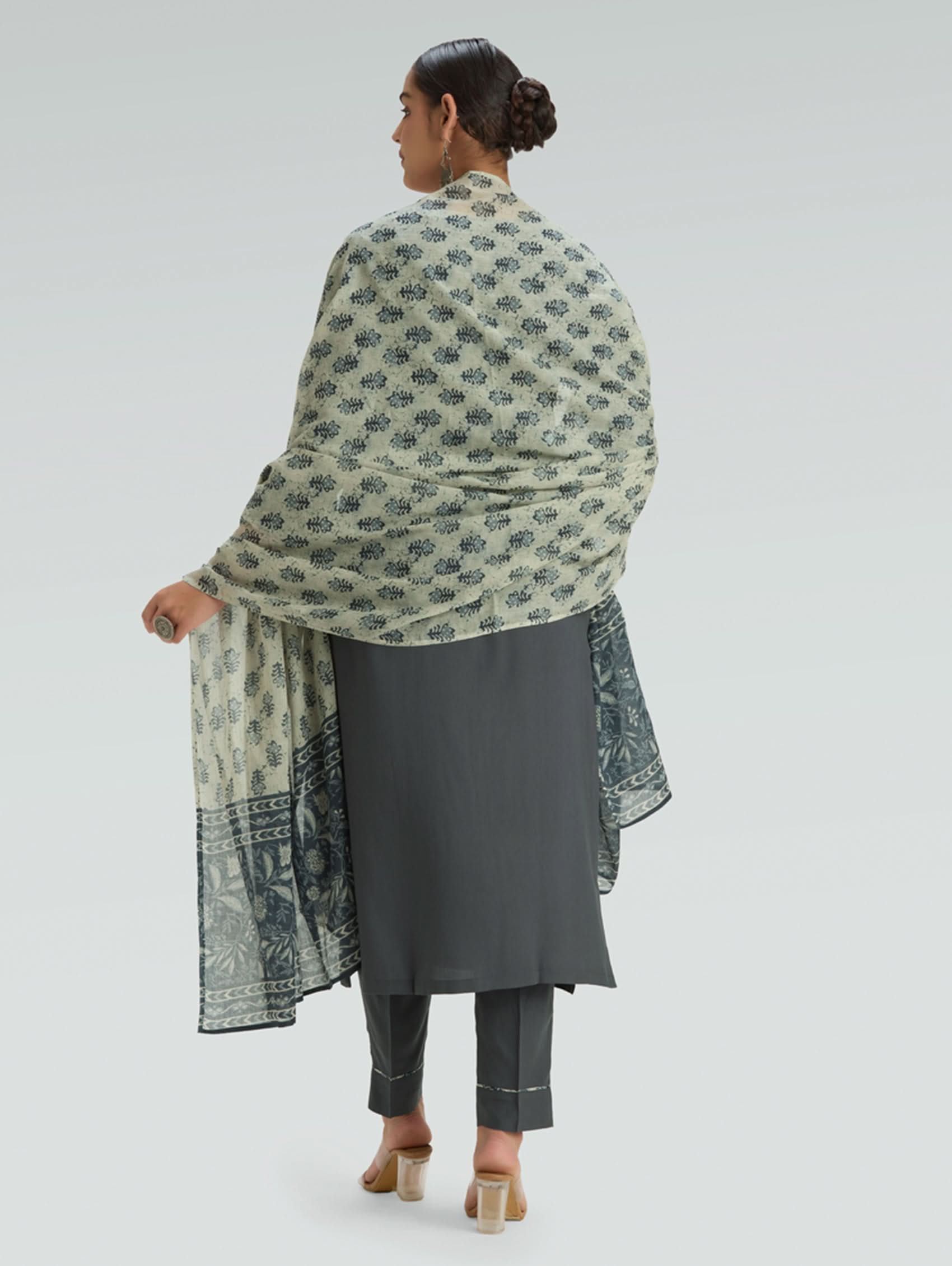 Woman wearing a gray outfit with a patterned Dupatta on a light gray background
