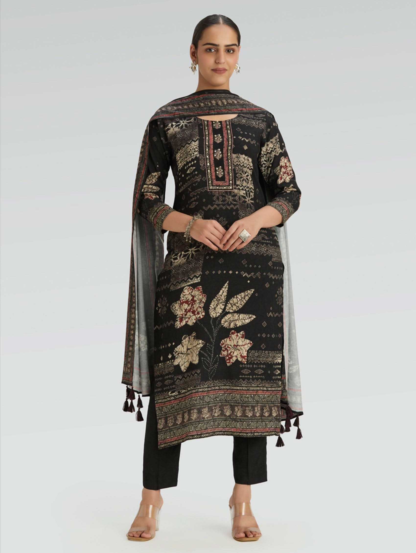 Woman wearing a black embroidered traditional outfit with a white background